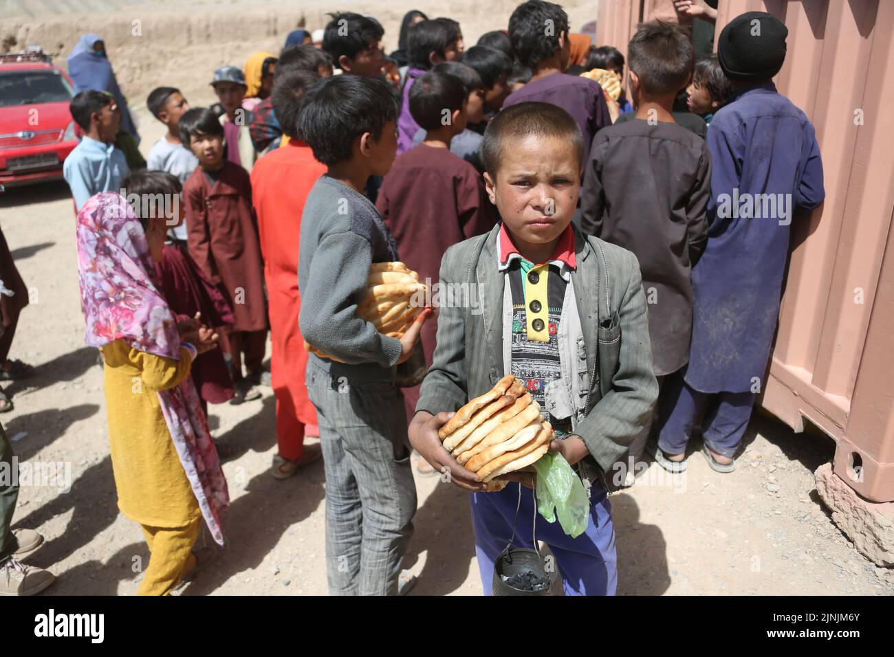 (220812) -- BAMYAN, Aug. 12, 2022 (Xinhua) -- Local kids receive food after attending training on cultural heritage knowledges in Bamyan province, Afghanistan, July 13, 2022. TO GO WITH 'Feature: Chinese scholars help protect cultural heritage in Afghanistan' (Photo by Saifurahman Safi/Xinhua) Stock Photo
