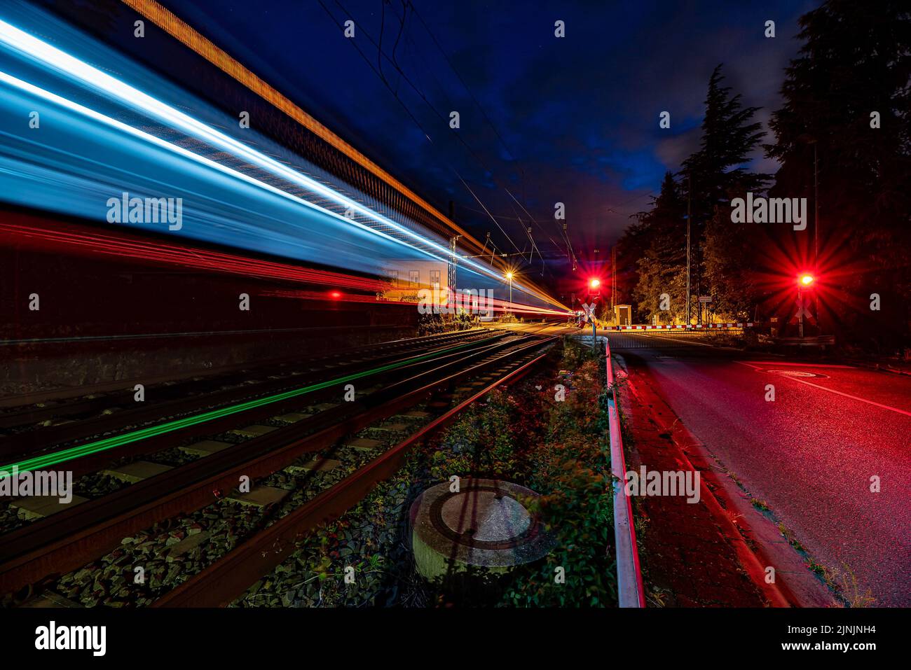 A vibrant light trails in an empty railroad at night, long exposure Stock Photo