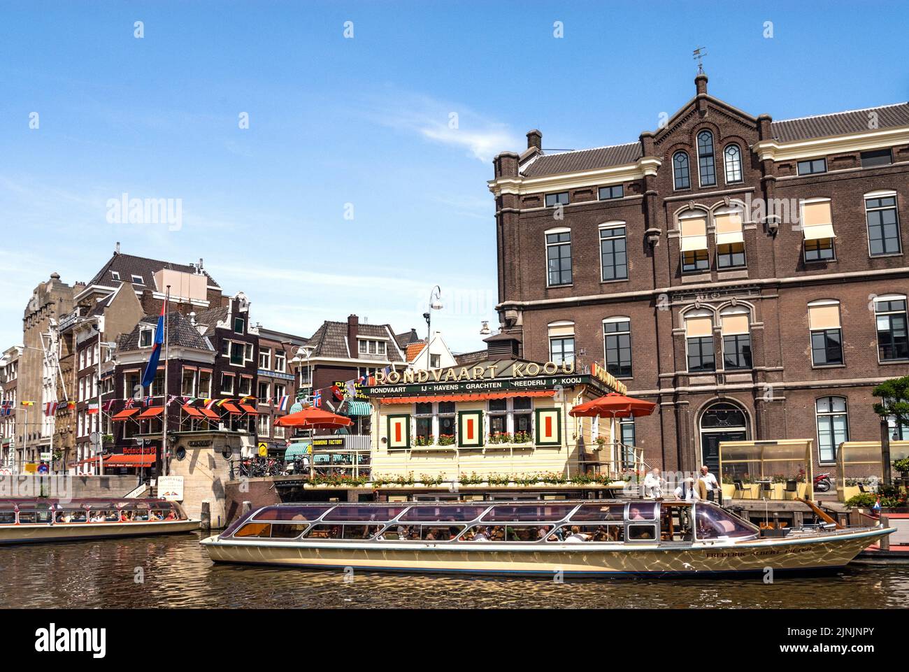 Typical sightseeing boats in a water channel in the city center of Amsterdam, Netherlands, Amsterdam Stock Photo