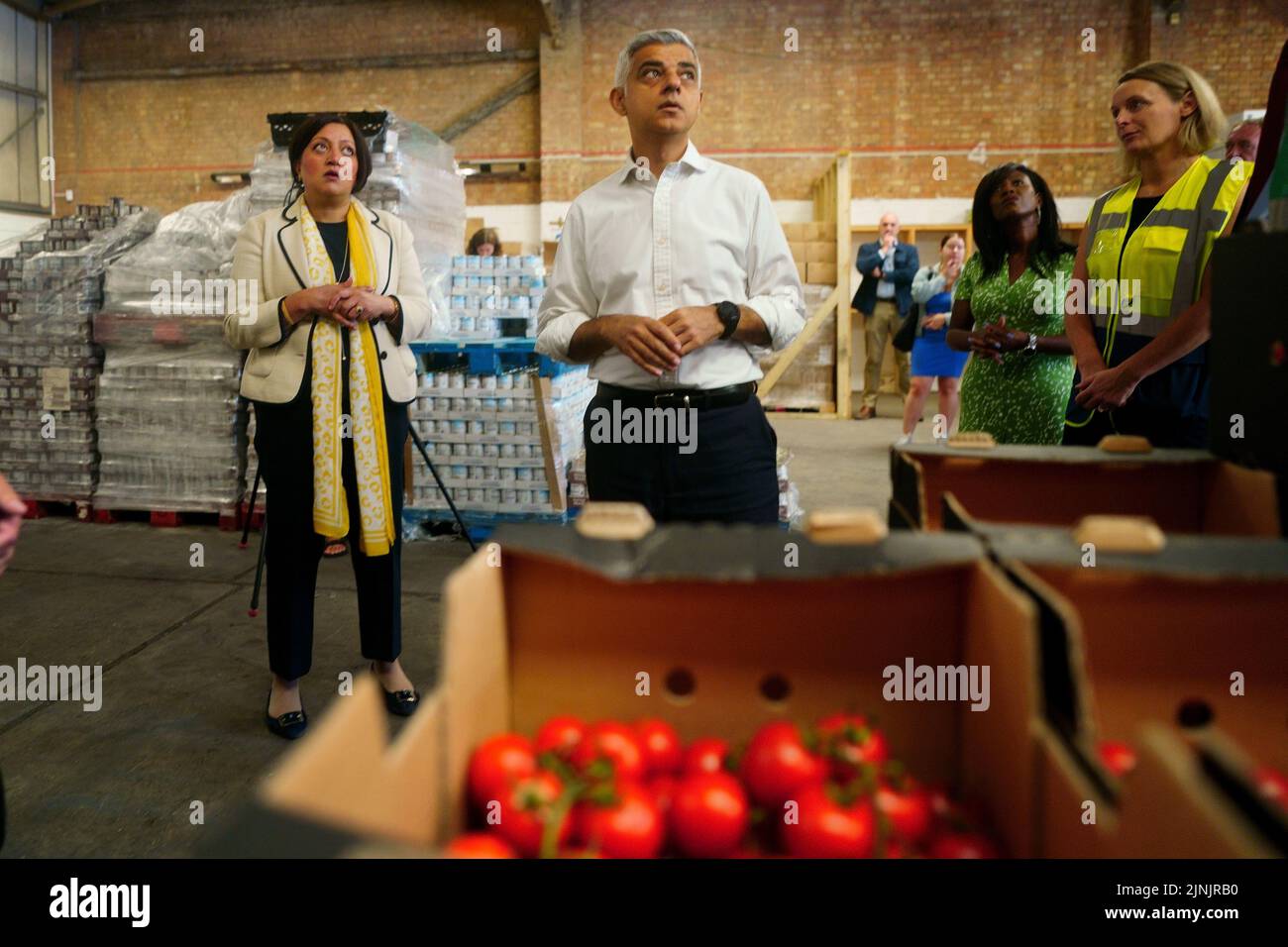 The Mayor of London, Sadiq Khan, looks at stores of food during a visit to the Newham Food Alliance warehouse hub in North Woolwich. The hub, which is run by Newham council, collects food and then delivers it to foodbanks across the borough.Picture date: Friday August 12, 2022. Stock Photo