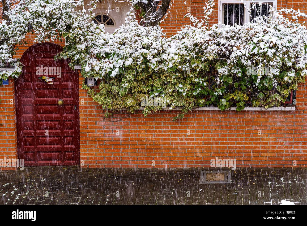 Facade of house with snowflakes falling on the street. Spain Stock ...