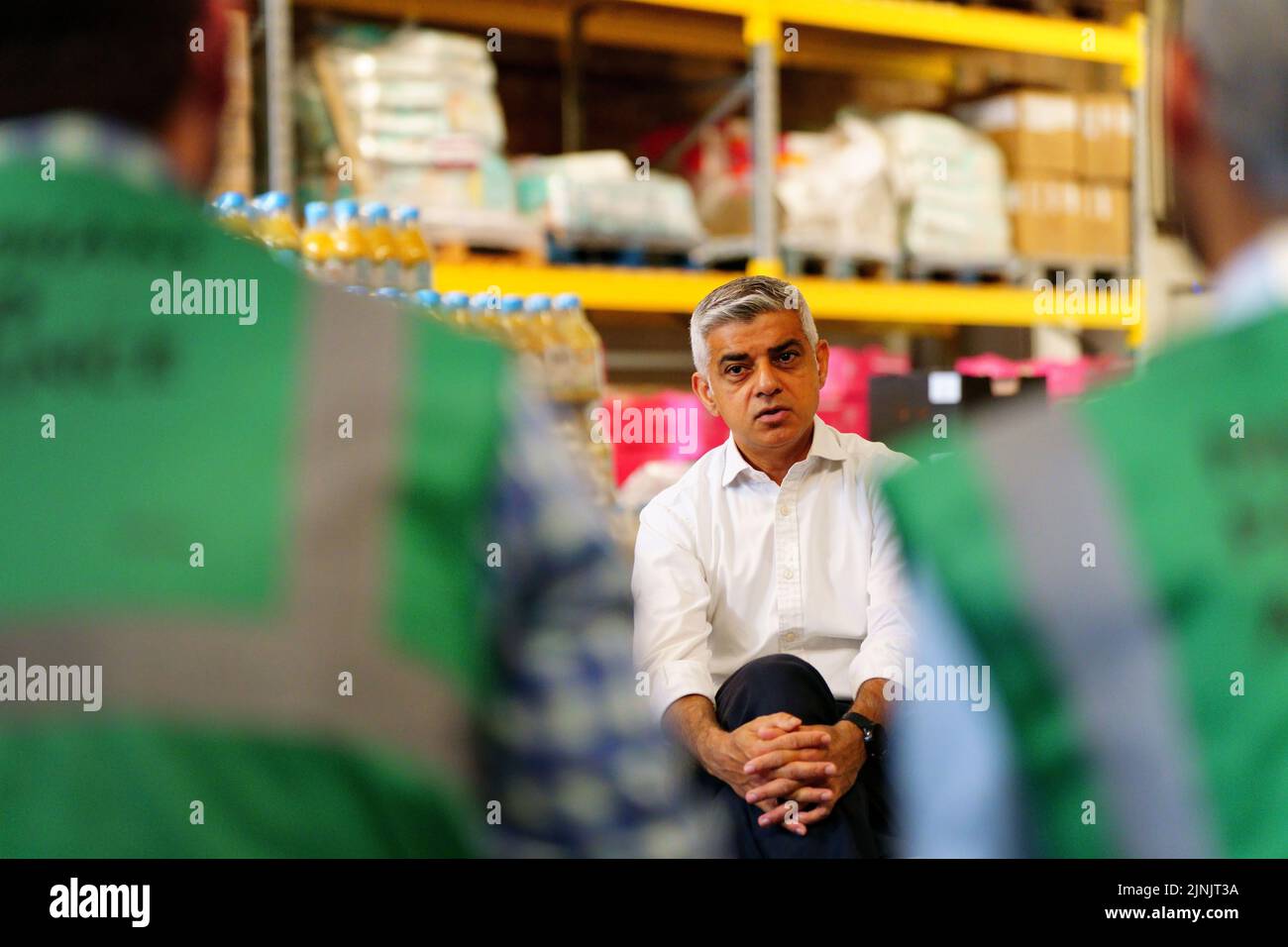 The Mayor of London, Sadiq Khan, talks to volunteers during a visit to the Newham Food Alliance warehouse hub in North Woolwich. The hub, which is run by Newham council, collects food and then delivers it to foodbanks across the borough.Picture date: Friday August 12, 2022. Stock Photo