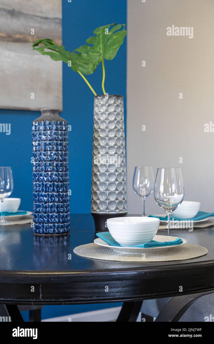 A dining room table decorated in blue accents inside a residential home. Stock Photo