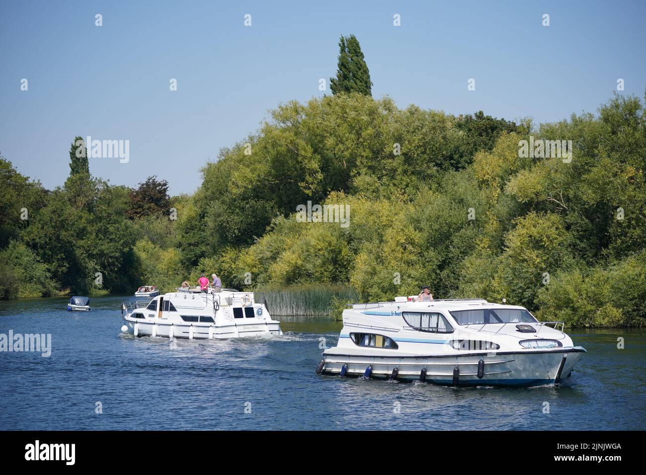 River traffic passes along the Thames near Bray in Berkshire. Parts of the South West, parts of southern and central England, and the East of England are to be moved into drought status, the Department for Environment, Food and Rural Affairs has said. Picture date: Friday August 12, 2022. Stock Photo