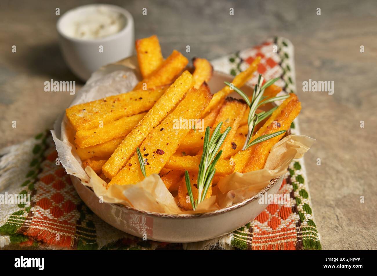 Homemade polenta fries with thyme, rosemary and yogurt sauce Stock Photo