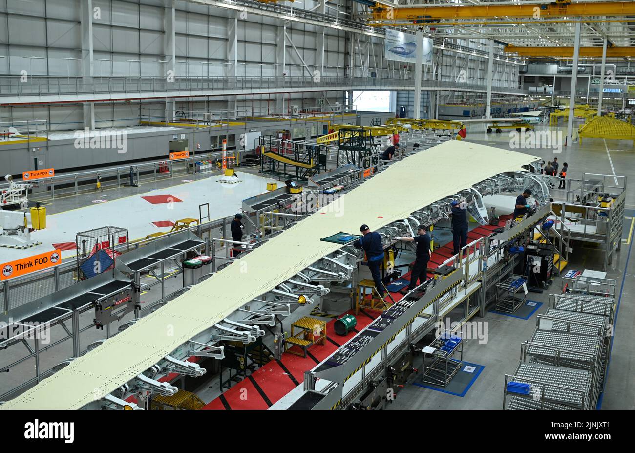 Member of staff work on a plane wing at the division manufacturing the wings for the A350 at the Airbus UK East Factory in North Wales. Picture date: Friday August 12, 2022. Stock Photo