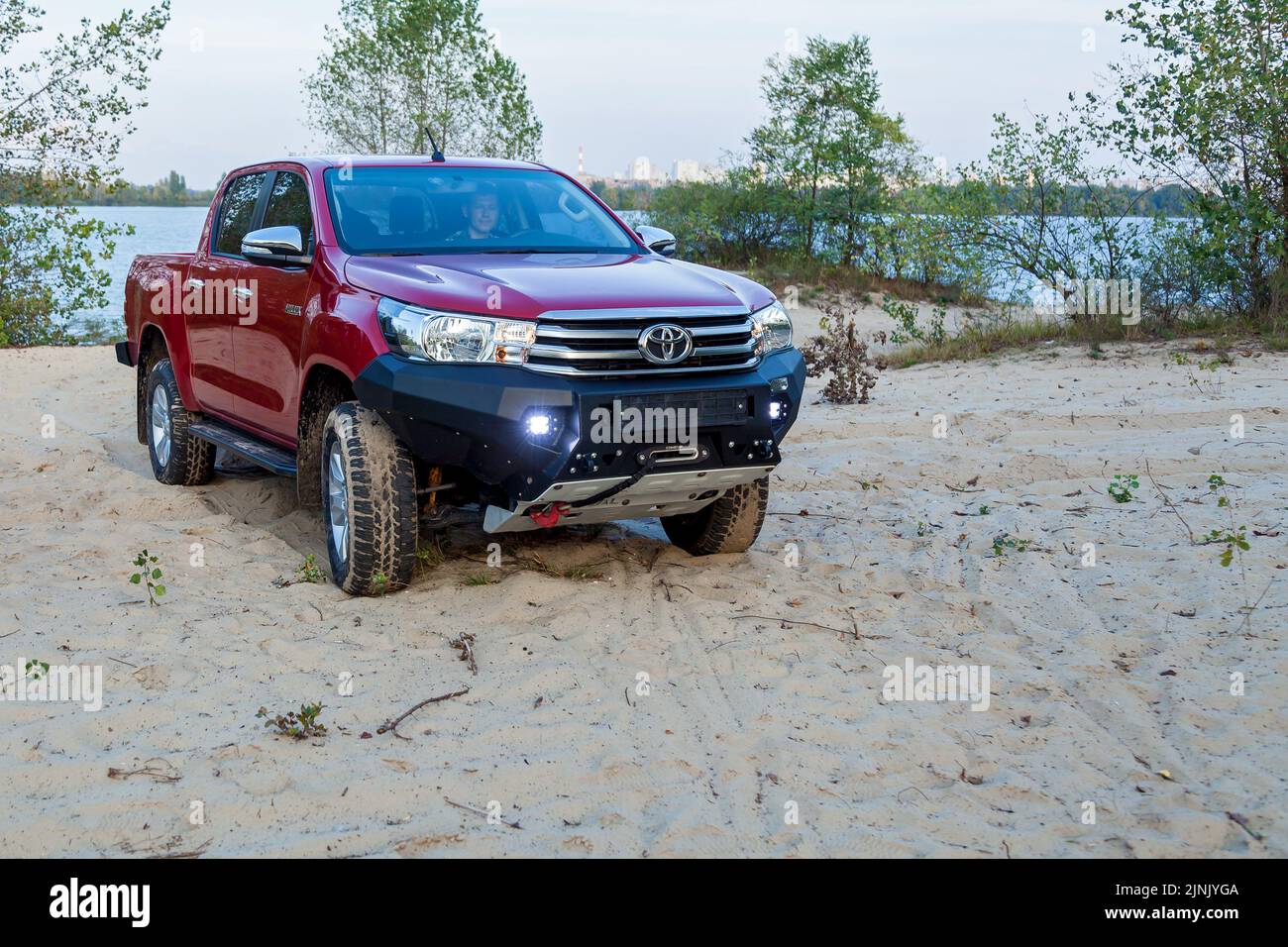 Ukraine Kiev October 10, 2020: Red new 4x4 pickup with Toyota Hilux double cab, with reinforced metal bumper and winch. Japanese car brand. Stock Photo