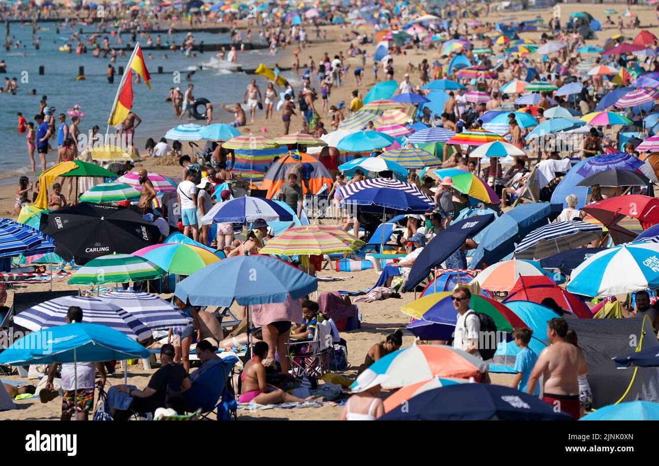 People gather in the hot weather at Bournemouth beach in Dorset. A drought is set to be declared for some parts of England on Friday, with temperatures to hit 35C making the country hotter than parts of the Caribbean. Picture date: Friday August 12, 2022. Stock Photo