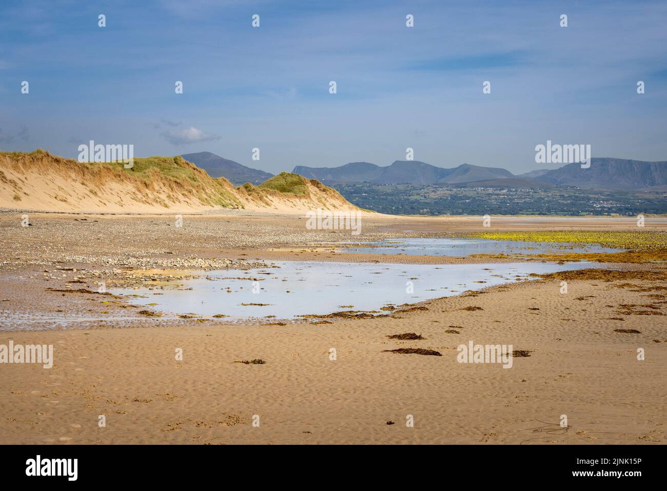The sand dunes of Newborough Warren at low-tide with Snowdonia Mountains in the background, Isle of Anglesey, North Wales Stock Photo