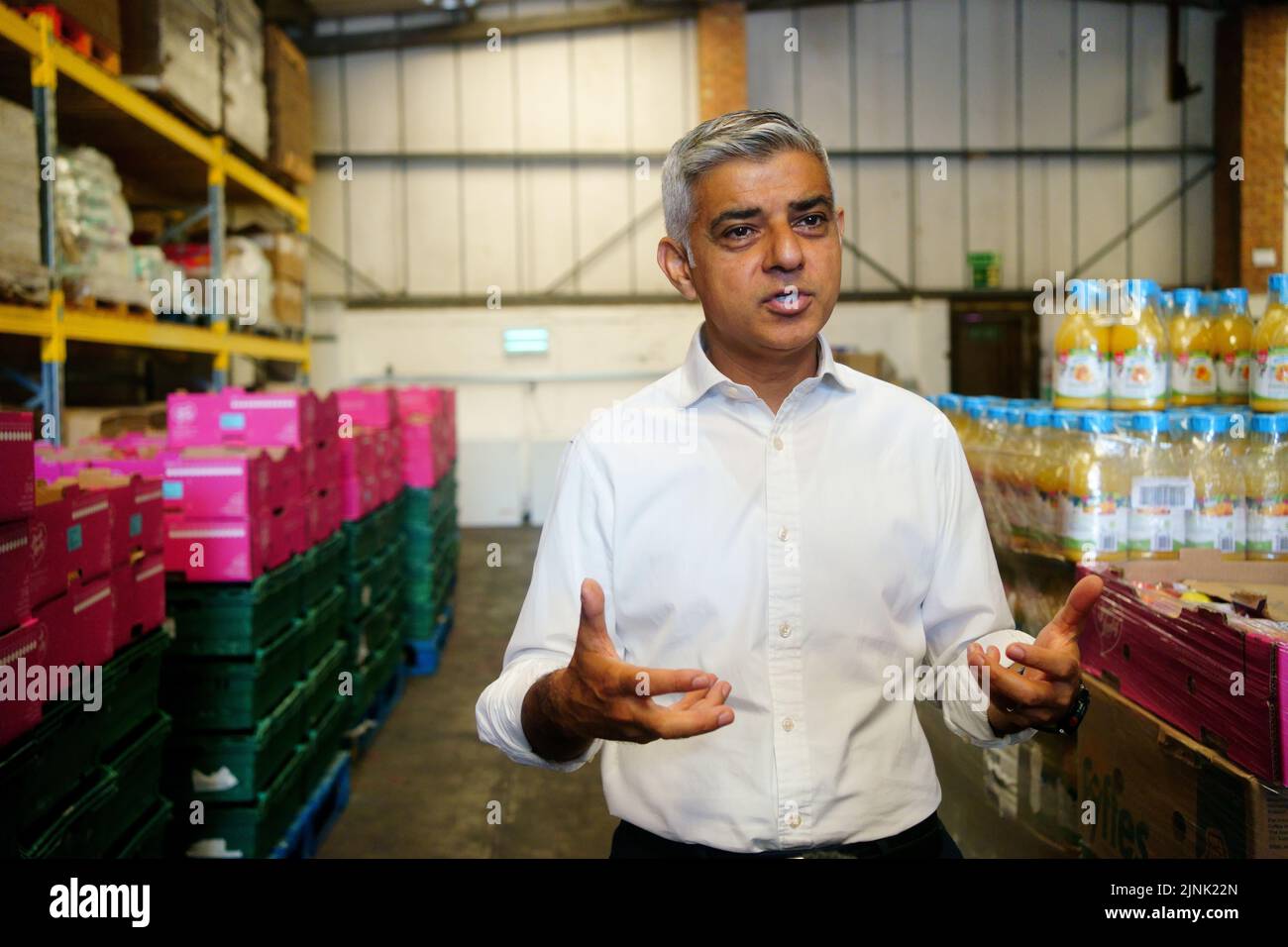 The Mayor of London, Sadiq Khan, talks to media during a visit to the Newham Food Alliance warehouse hub in North Woolwich. The hub, which is run by Newham council, collects food and then delivers it to foodbanks across the borough.Picture date: Friday August 12, 2022. Stock Photo
