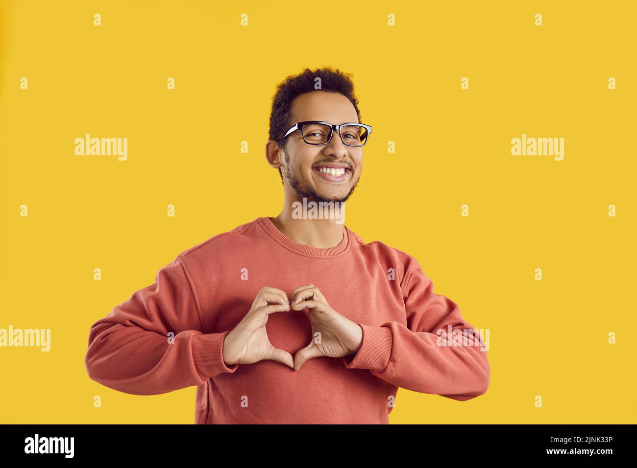 Portrait of smiling black man show heart hand gesture Stock Photo