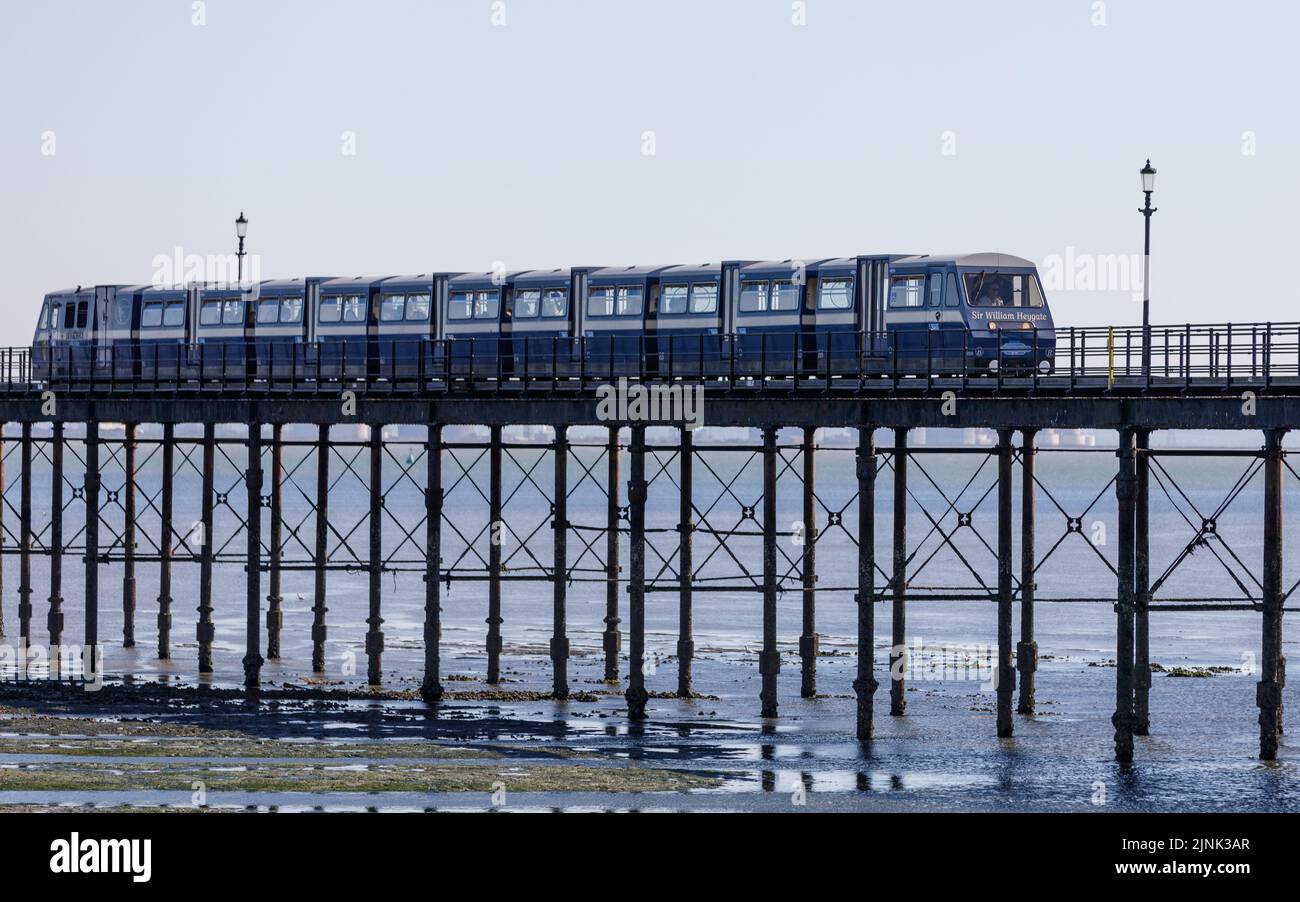 Southend pleasure pier at low tide with pier train on a bright, blue sky sunny day during the summer heatwave in the UK Stock Photo