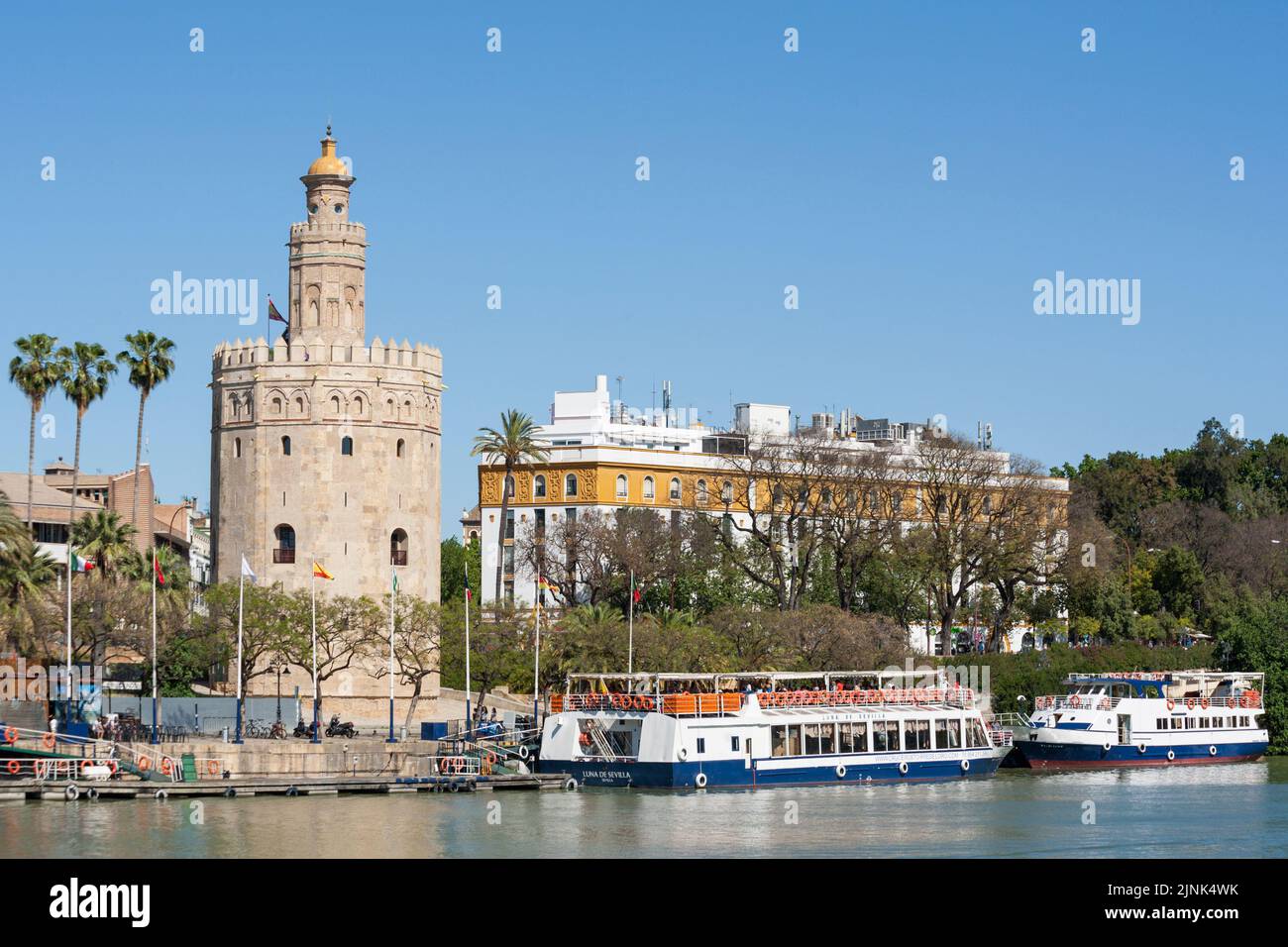 Excursion boats moored at the pier of 13th century watchtower Torre del Oro at Seville, Spain Stock Photo