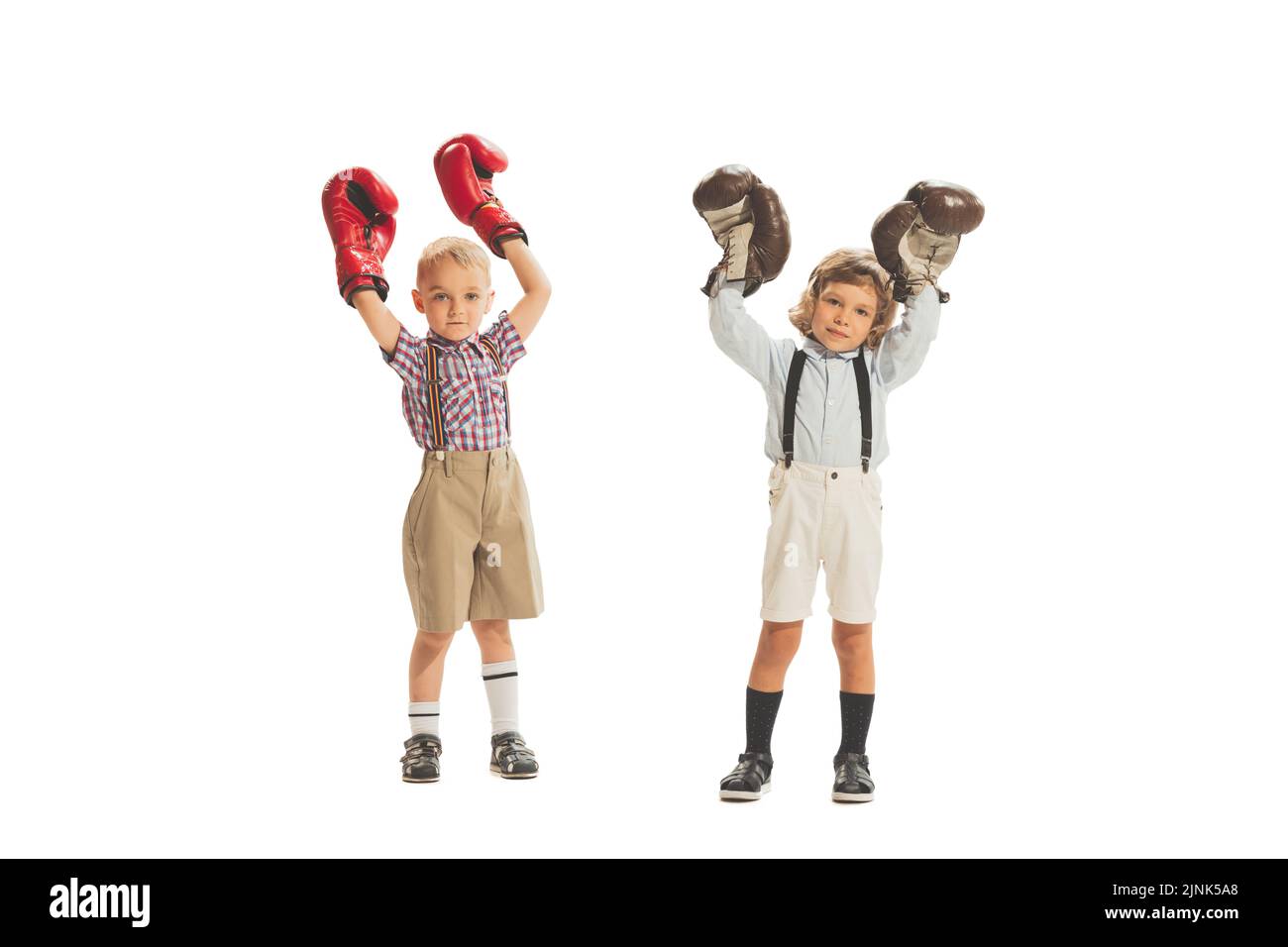 Funny kids in huge boxing gloves boxing together isolated on white