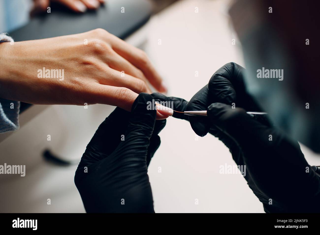 Manicure process female hands finger nails polish at nail salon Stock