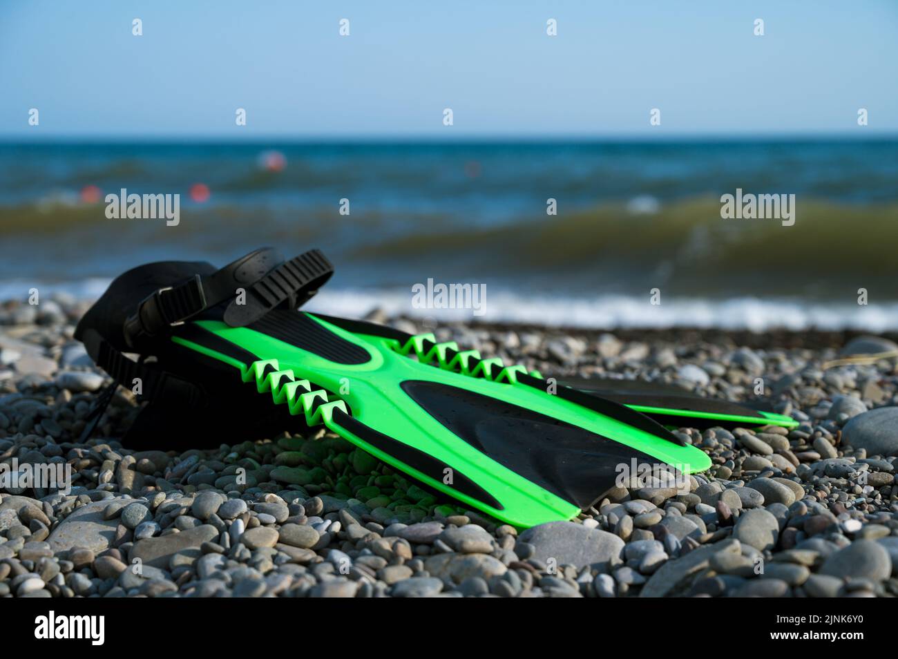 Fins on a pebble beach next to the sea. Summer vacation Stock Photo - Alamy