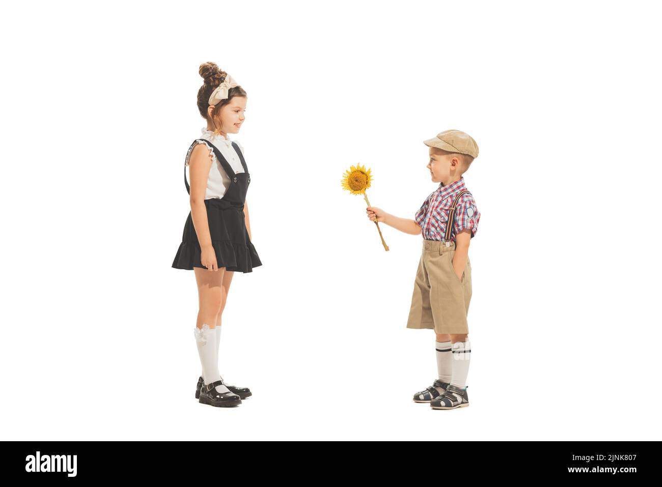 Portrait of little boy and girl, charming kids in retro style outfit, american fashion of 60s, 70s years isolated on white background. Art, childhood Stock Photo