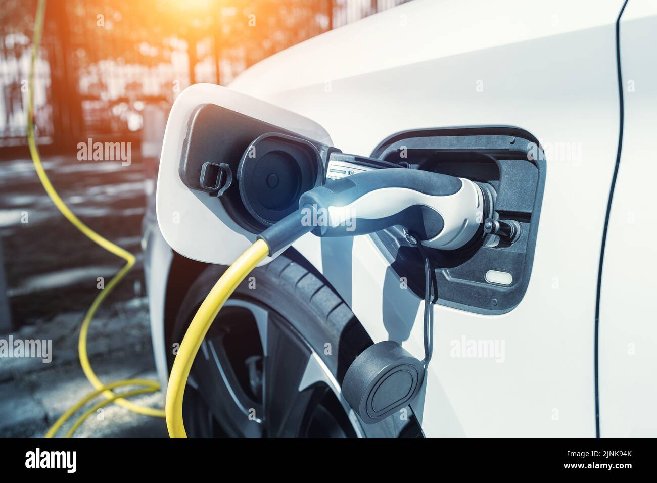 Close-up modern electric plug-in hybrid car parked near fast charger ...