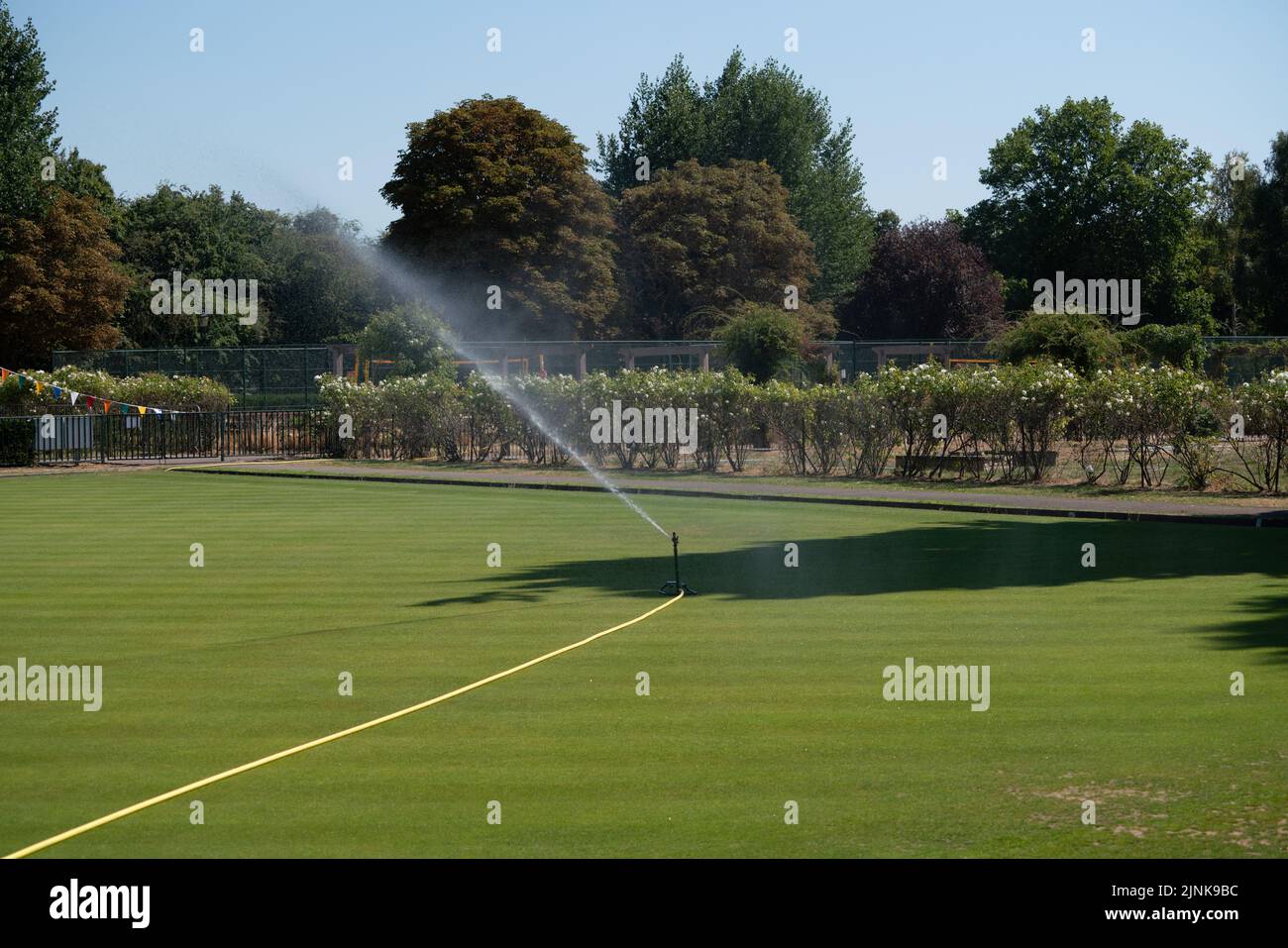 Wimbledon London, UK. 12 August 2022 .  A sprinkler watering the grass  at a sports ground in Wimbledon, south west London The Met Office has issued an amber extreme heat warning across England and Wales lasting for the rest of the week as temperatures are expected to hit up to 37c this weekend . Credit. amer ghazzal/Alamy Live News Stock Photo