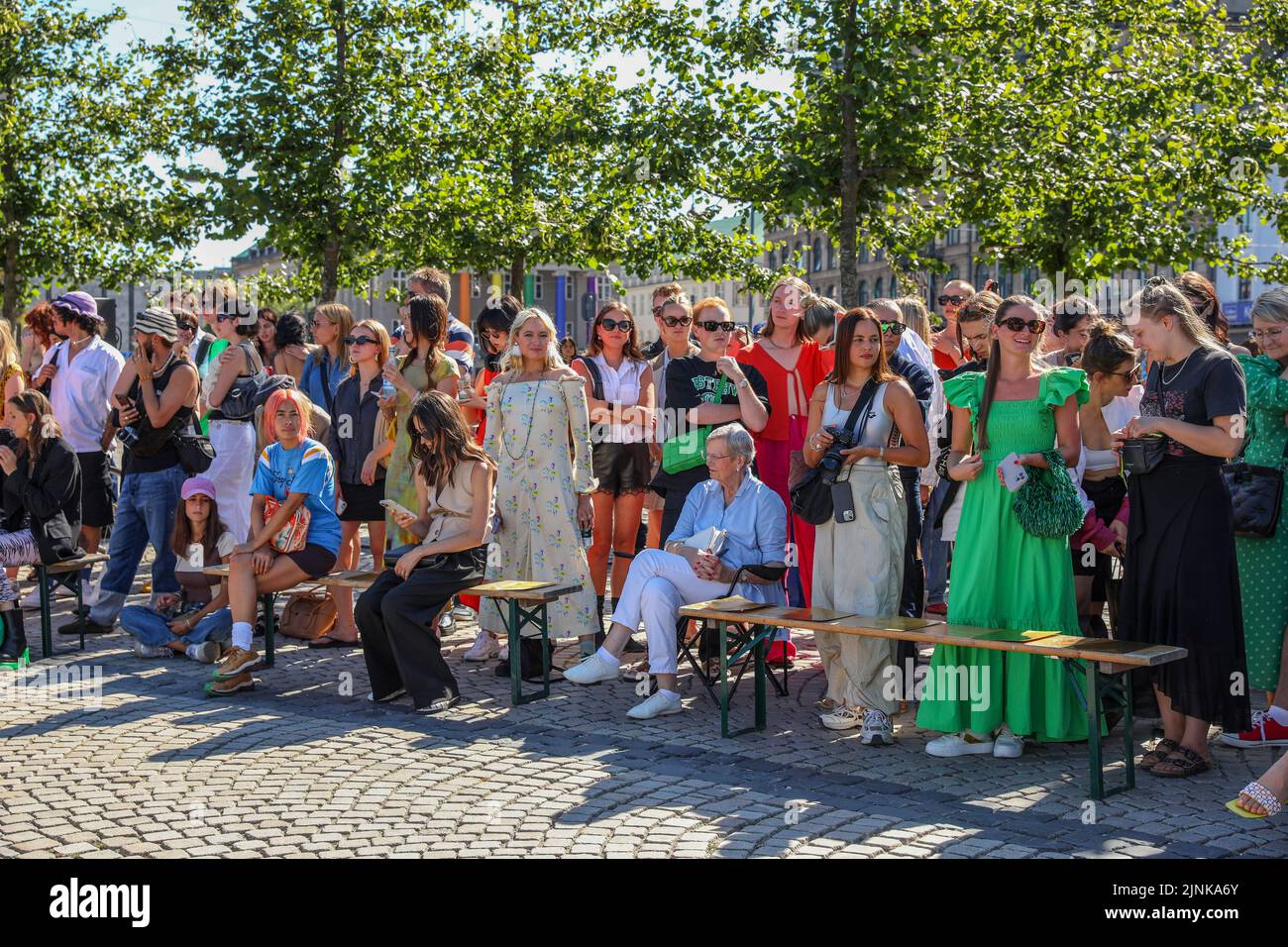 Guests waiting for the start of the fashion show of Saks Potts brand. Copenhagen Fashion Week is the biggest fashion event in the King's New Square, Scandinavia. This summer Fashion Week runs from 9th to 12th August. On the streets of the capital of Denmark a lot of fashionably dressed people. Stock Photo