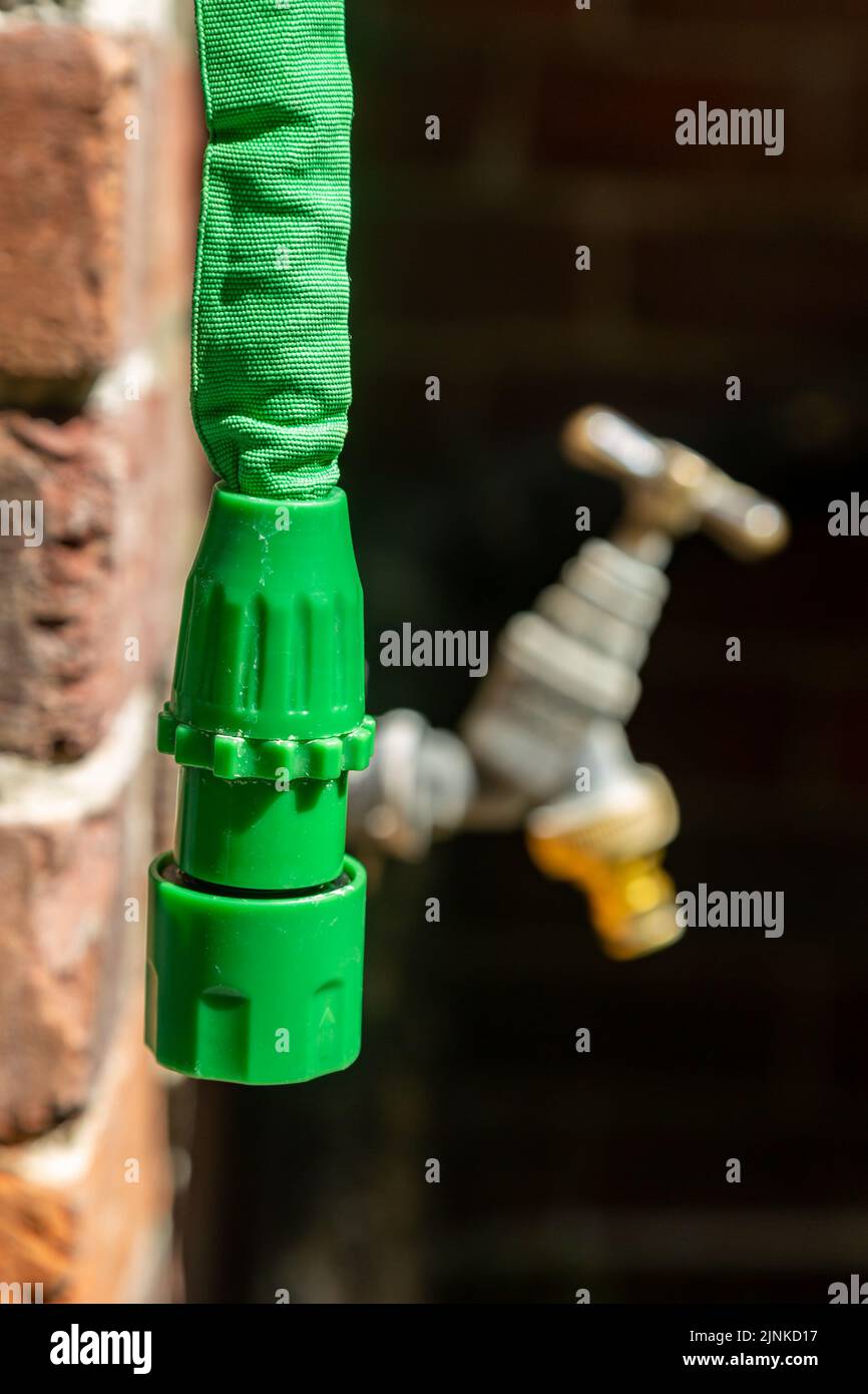 A hosepipe disconnected from an outside tap during a hosepipe ban in the UK Stock Photo