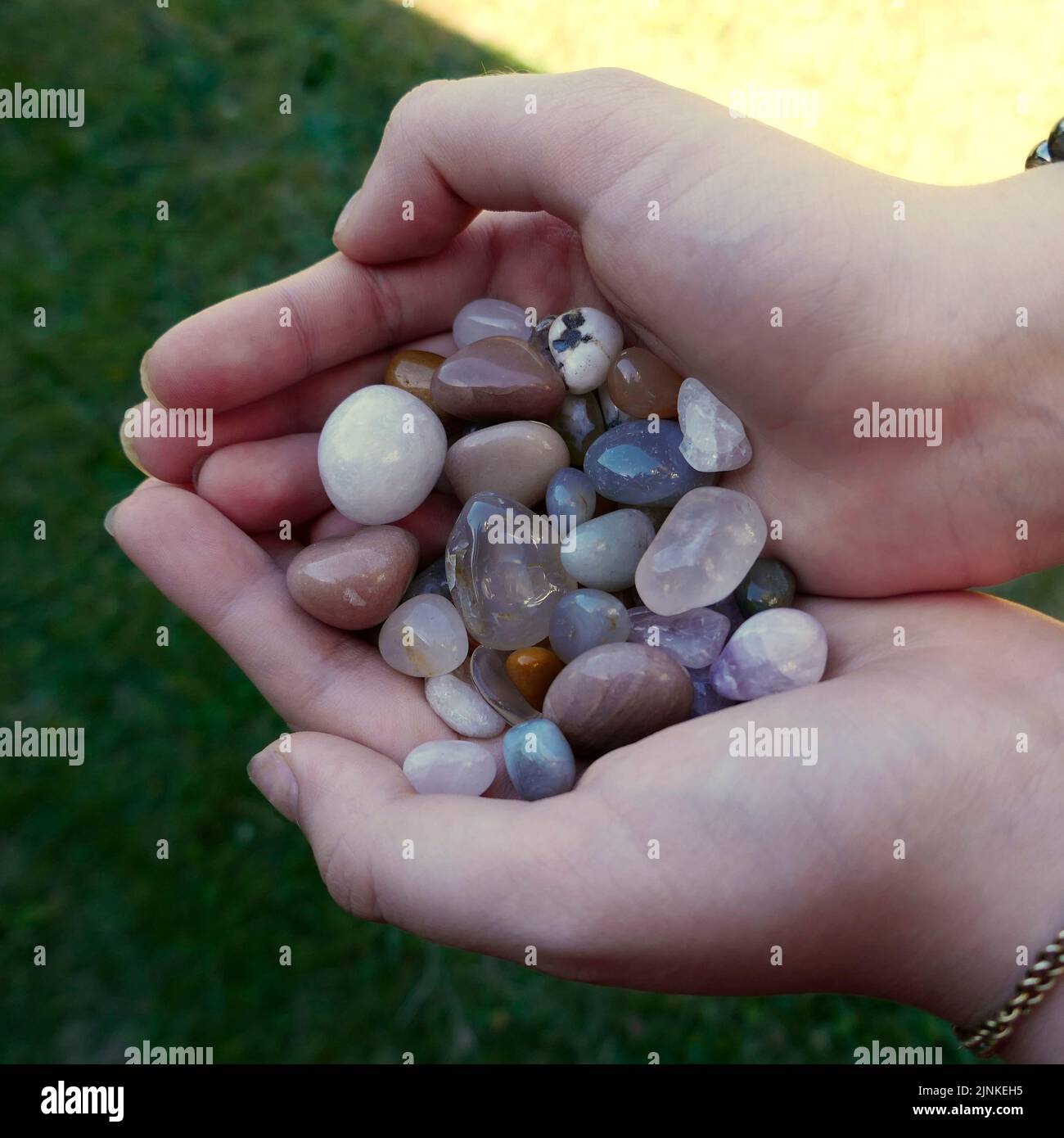 Tumble finished mixture of semi-precious stones in the hands of a girl Stock Photo