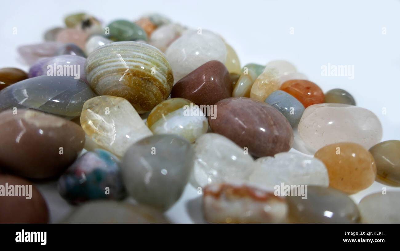 A heap of tumble finished mixture of semi-precious stones on a white background. Stock Photo