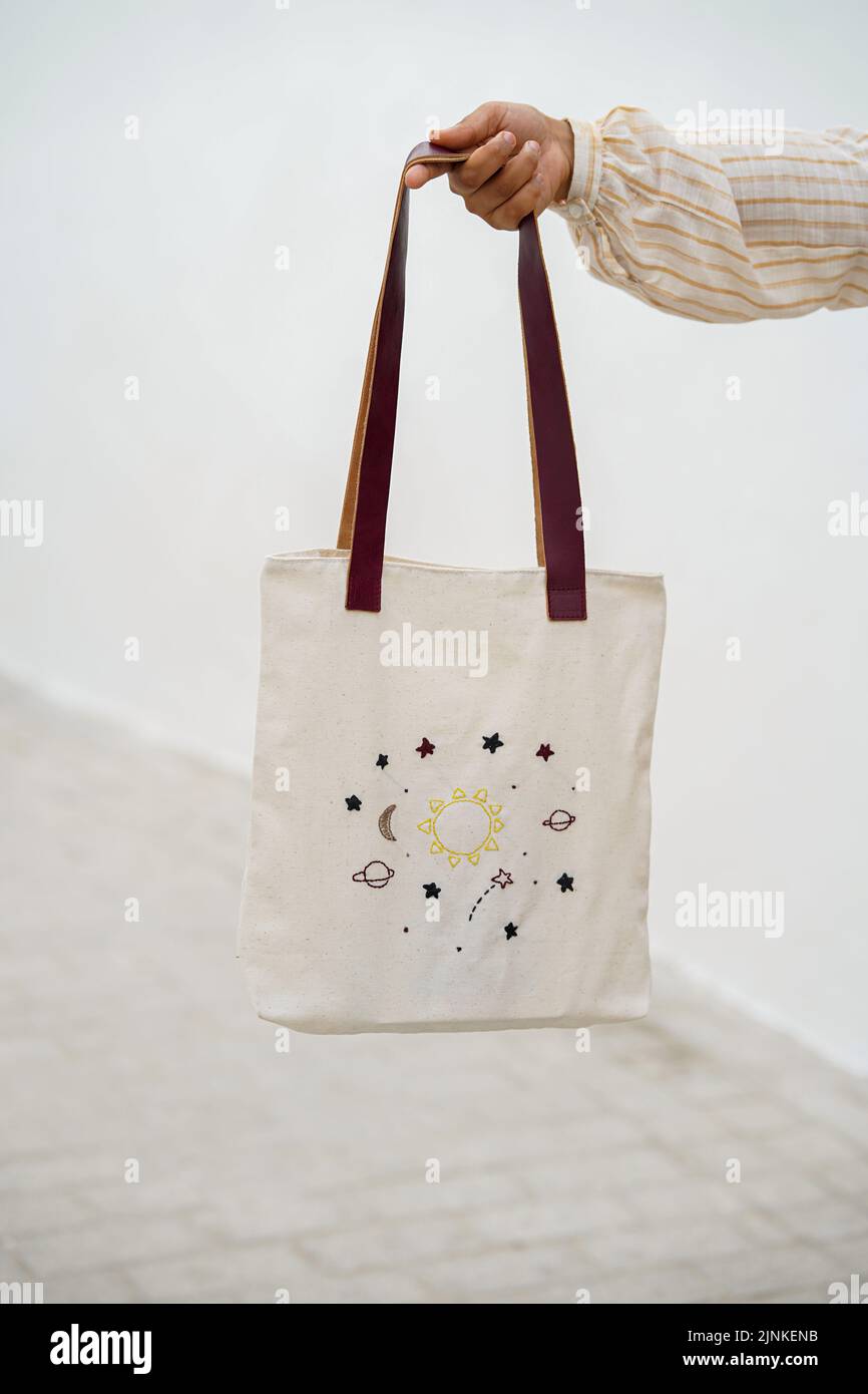 Blank canvas tote bag, design mockup with hand. Handmade shopping bags. Stock Photo