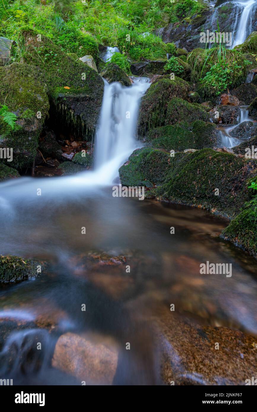 A vertical shot of a waterfall on the mossy rocks Stock Photo - Alamy