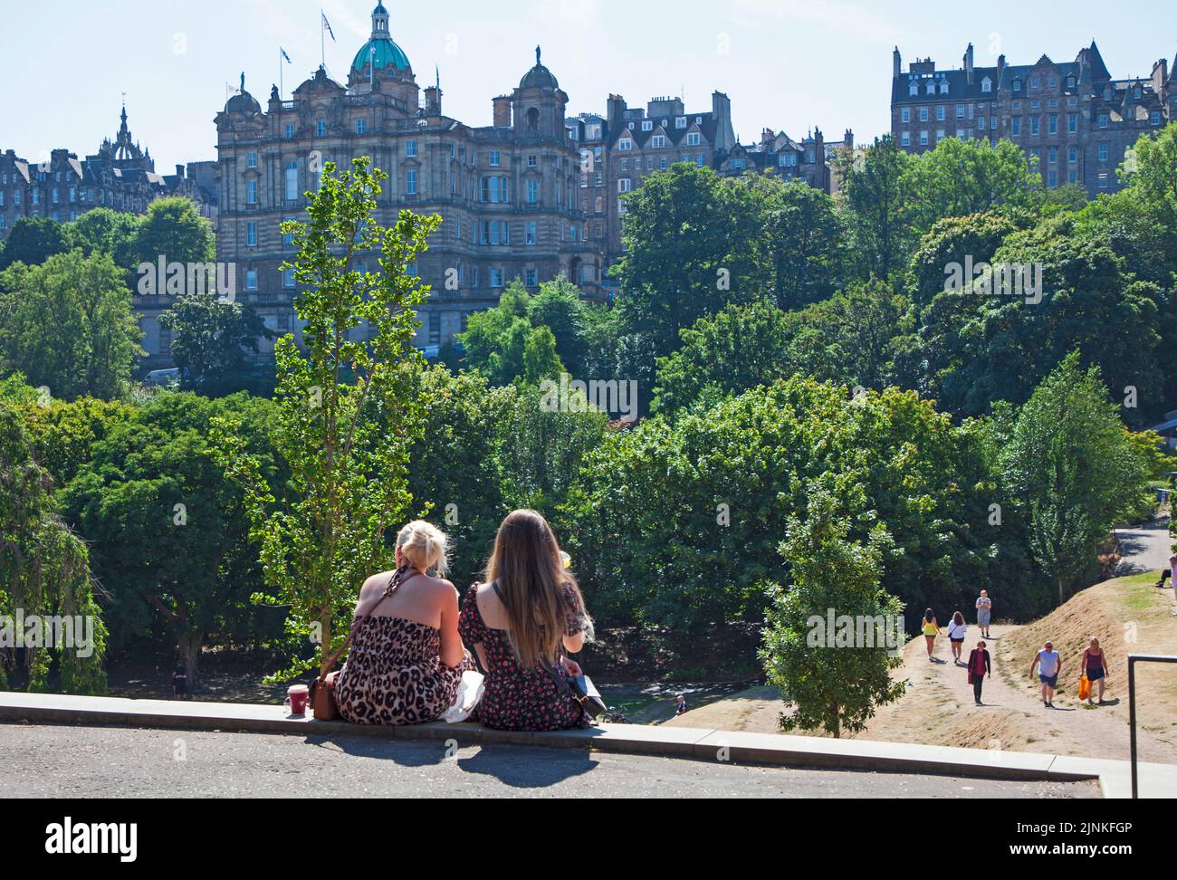Edinburgh city centre, Scotland, UK. 12th August 2022. Edinburgh busy for the 8th day of Edinburgh Festival Fringe at various venues in the capital city for the end of the first full week. Temperature 21 degrees centigrade for those out and about. Pictured: People enjoying the hot weather, relaxing and walking in Princes Street Gardens East Credit: Arch White/alamy live news. Stock Photo