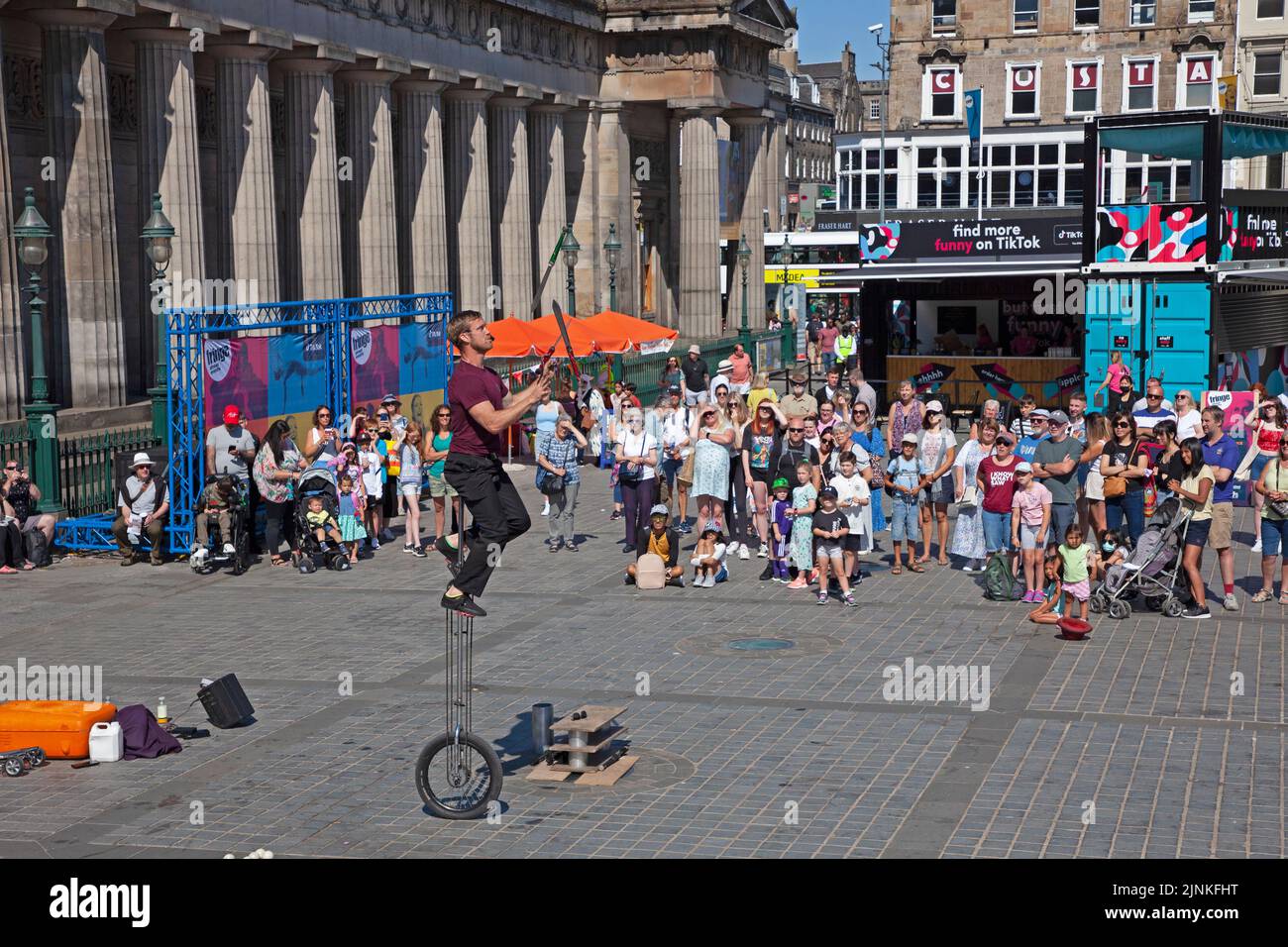 Edinburgh city centre, Scotland, UK. 12th August 2022. Edinburgh busy for the 8th day of Edinburgh Festival Fringe at various venues in the capital city for the end of the first full week. Temperature 21 degrees centigrade for those out and about. Pictured: A male street performer entertains a decent crowd at The Mound pitch, just before noon. Credit: Arch White/alamy live news. Stock Photo