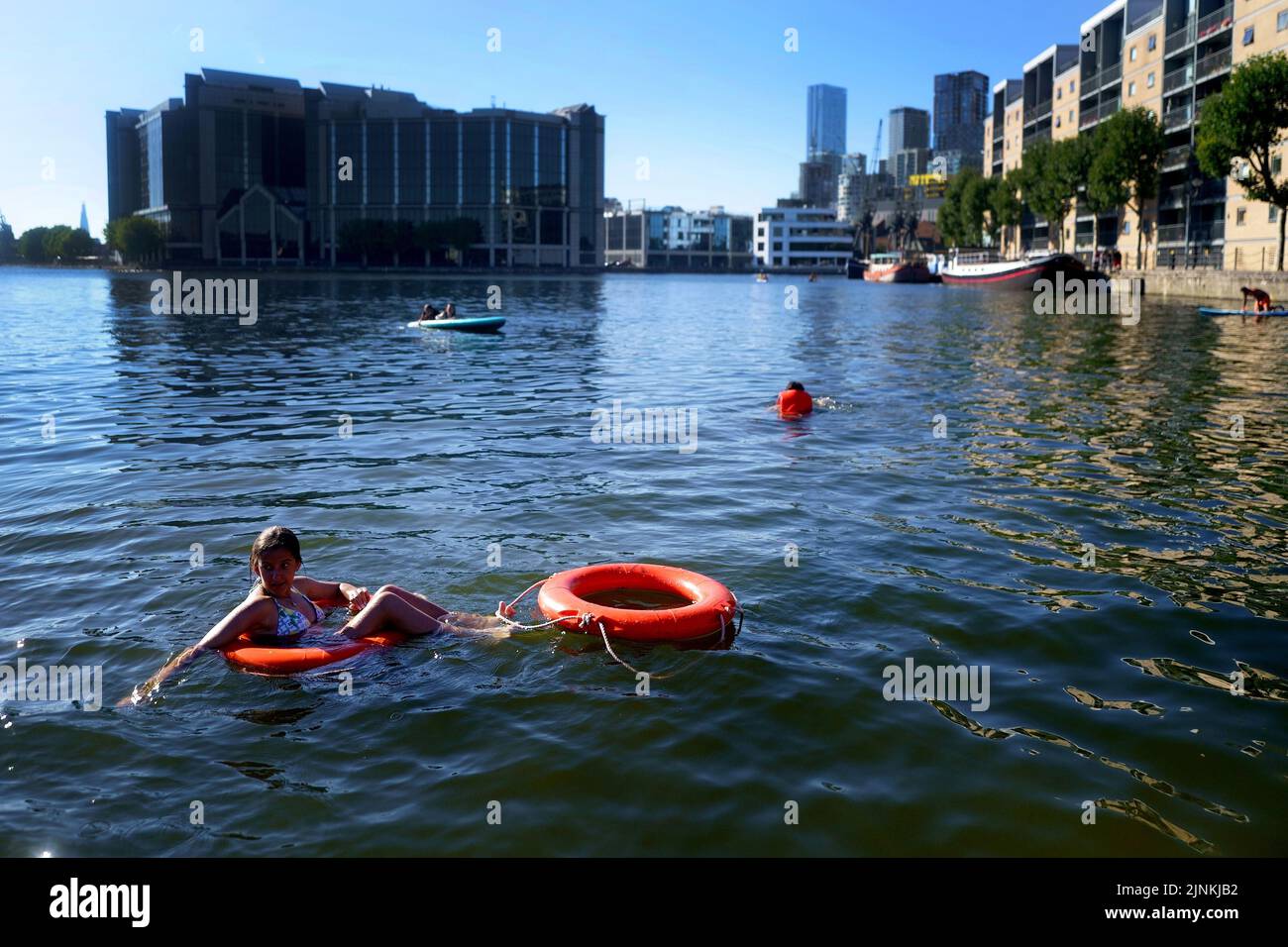 Children play in water in the Isle of Dogs, in east London. A drought is set to be declared for some parts of England on Friday, with temperatures to hit 35C making the country hotter than parts of the Caribbean. Picture date: Friday August 12, 2022. Stock Photo