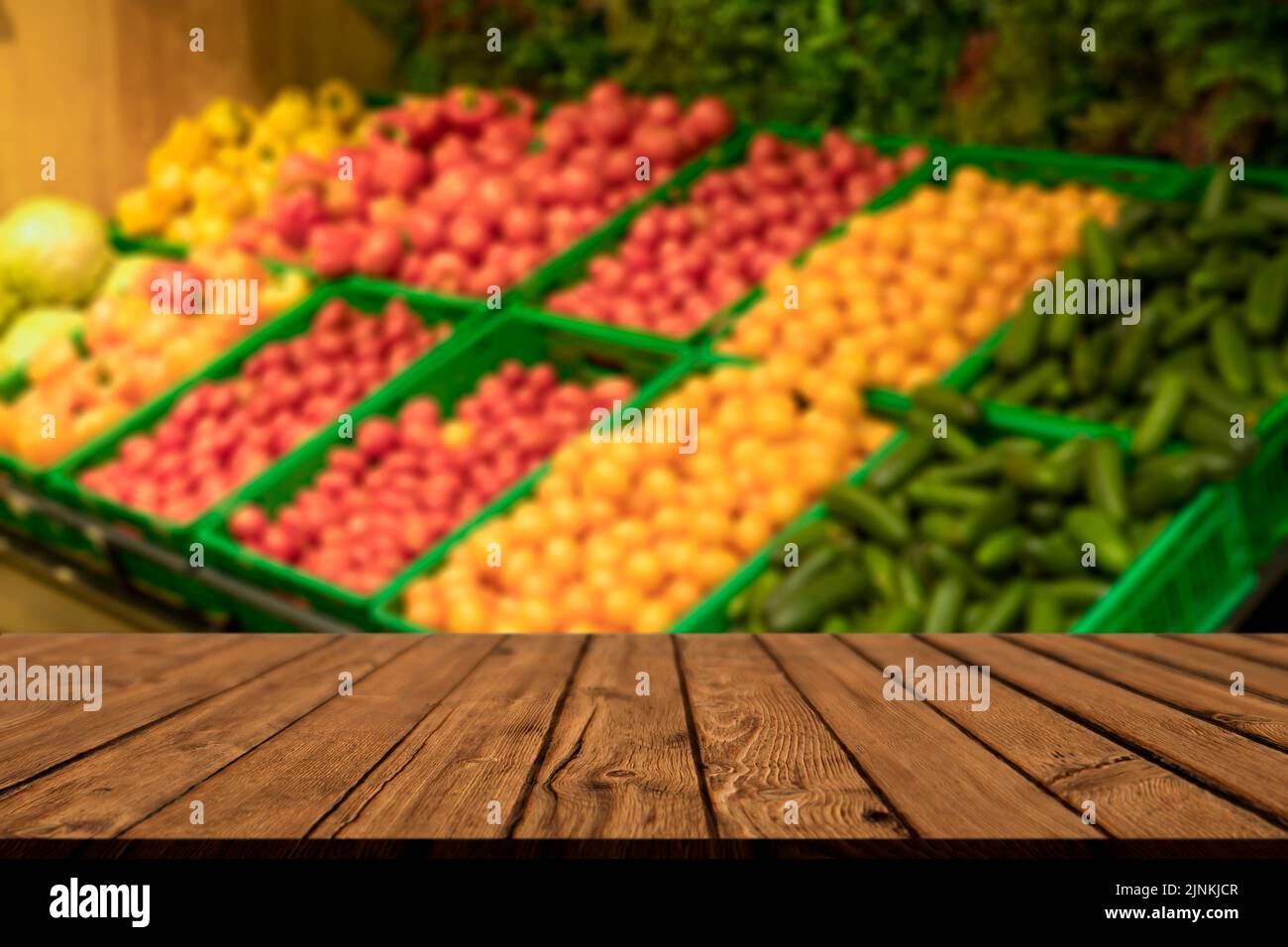 Supermarket table background. A counter with blurred vegetables and empty wooden table. Grocery, food, products, retail concept. High quality photo Stock Photo