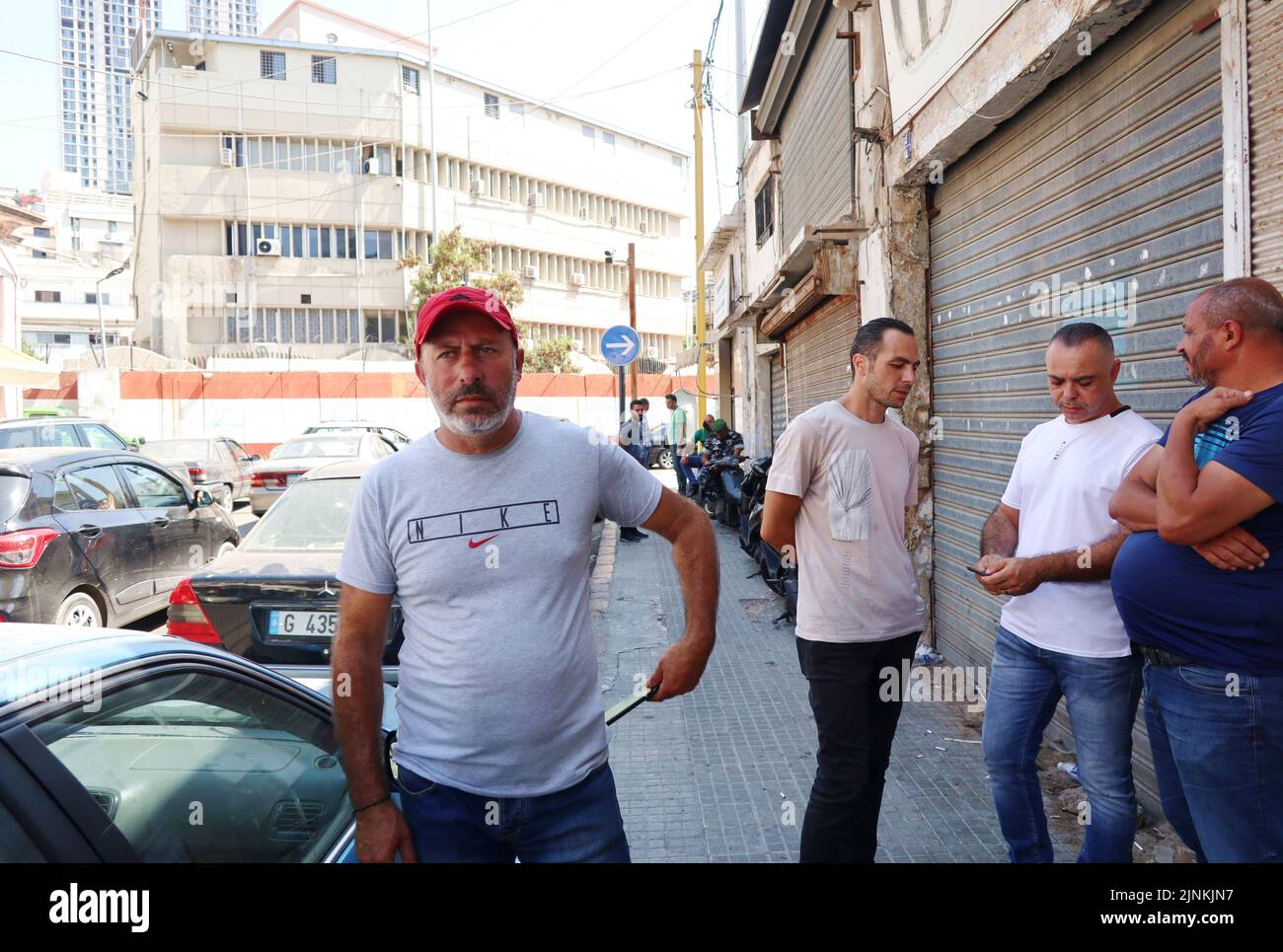 Atef al-Sheikh Hussein (red cap) is waiting for the release of his brother Bassam al-Sheikh Hussein, deteinee in the headquarter of Intelligence Police Department, Beirut, Lebanon, August 12 2022. On August 11 Bassam al-Sheikh entered the Federal Bank in Hamra district, Beirut, with a gun and some fuel threatening to set himself on fire unless he was allowed to take out his own money. According to Lebanese medias, the man wanted to withdraw his 210.000 USD deposit, which was frozen by the bank since the outbreak of the country's economic crisis in 2019. In the end the depositor surrendered and Stock Photo