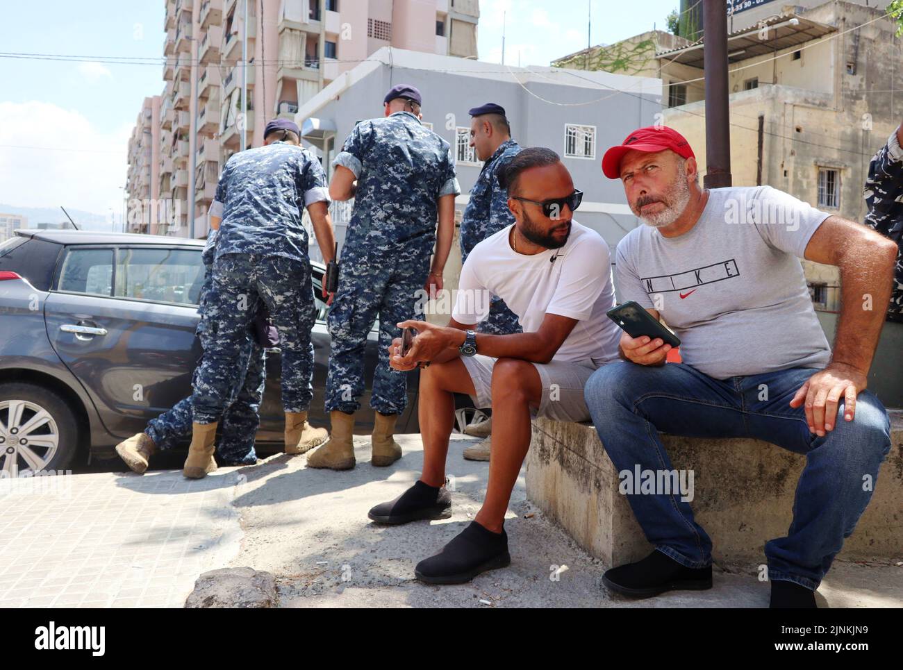 Atef al-Sheikh Hussein (red cap) is waiting for the release of his brother Bassam al-Sheikh Hussein, deteinee in the headquarter of Intelligence Police Department, Beirut, Lebanon, August 12 2022. On August 11 Bassam al-Sheikh entered the Federal Bank in Hamra district, Beirut, with a gun and some fuel threatening to set himself on fire unless he was allowed to take out his own money. According to Lebanese medias, the man wanted to withdraw his 210.000 USD deposit, which was frozen by the bank since the outbreak of the country's economic crisis in 2019. In the end the depositor surrendered and Stock Photo