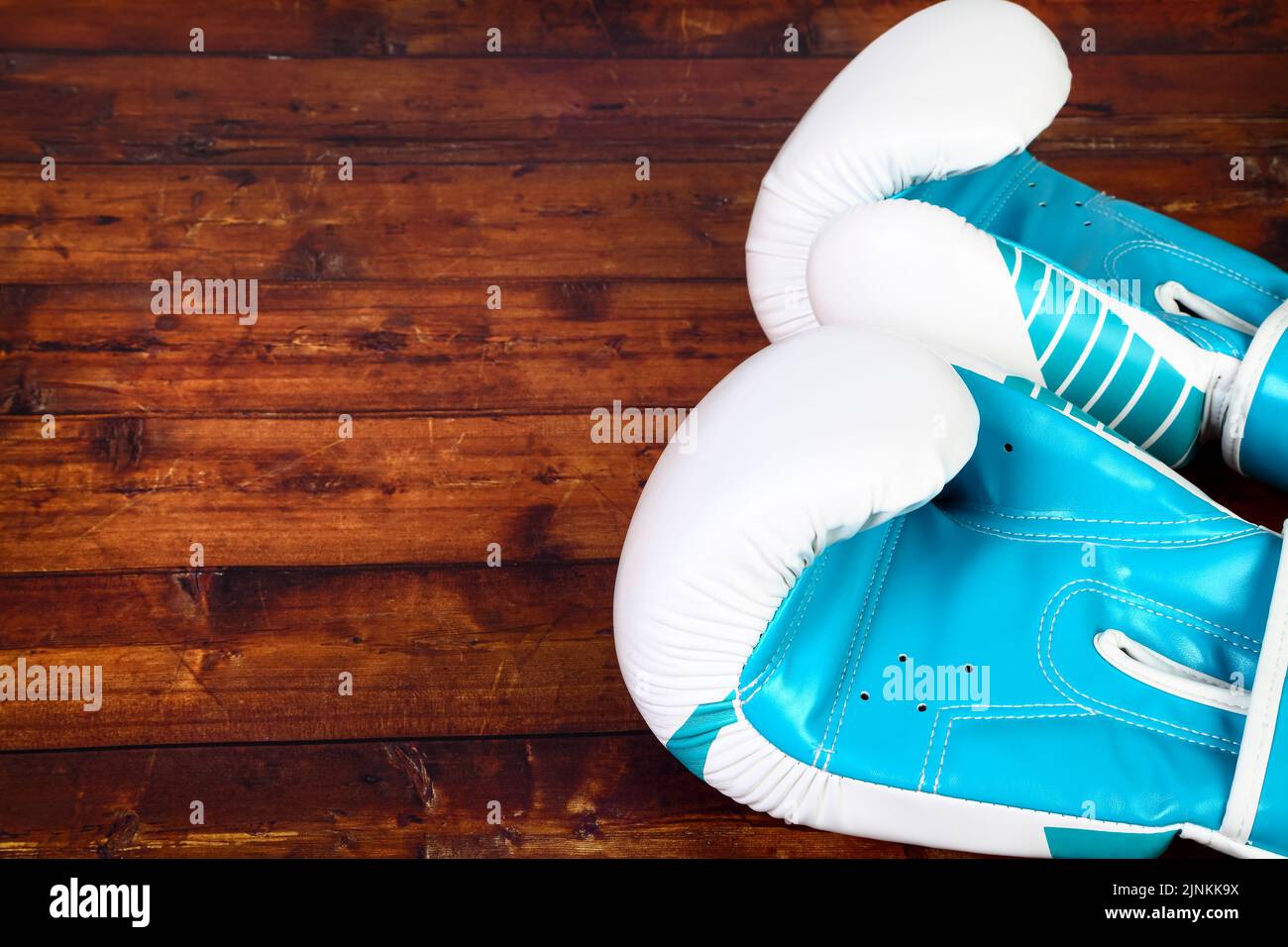 Two blue boxing glove isolated on a wooden background Stock Photo - Alamy