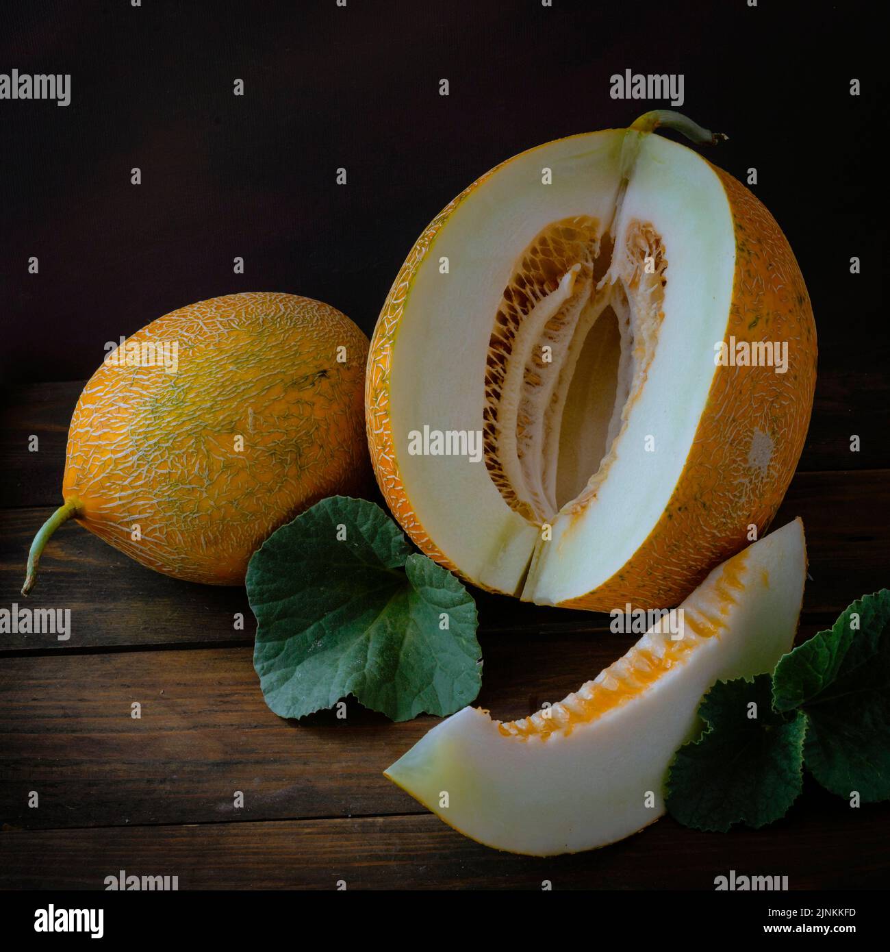 fresh Whole and sliced of Japanese melons, honey melon cantaloupe (Cucumis melo) leaf wooden table background. fruit summer Fruits healthcare concept. Stock Photo