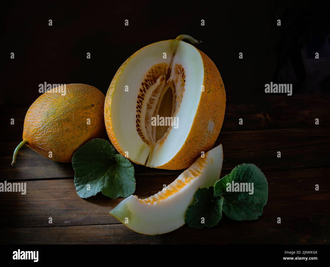 fresh Whole and sliced of Japanese melons, honey melon cantaloupe (Cucumis melo) leaf wooden table background. fruit summer Fruits healthcare concept. Stock Photo