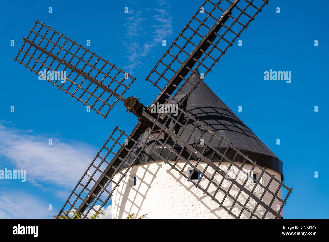 Beautiful windmill isolated in top of a hill near to Consuegra city in Castilla-La Mancha - Spain. Cloudy day. Giants Land and story of Don Quixote Stock Photo
