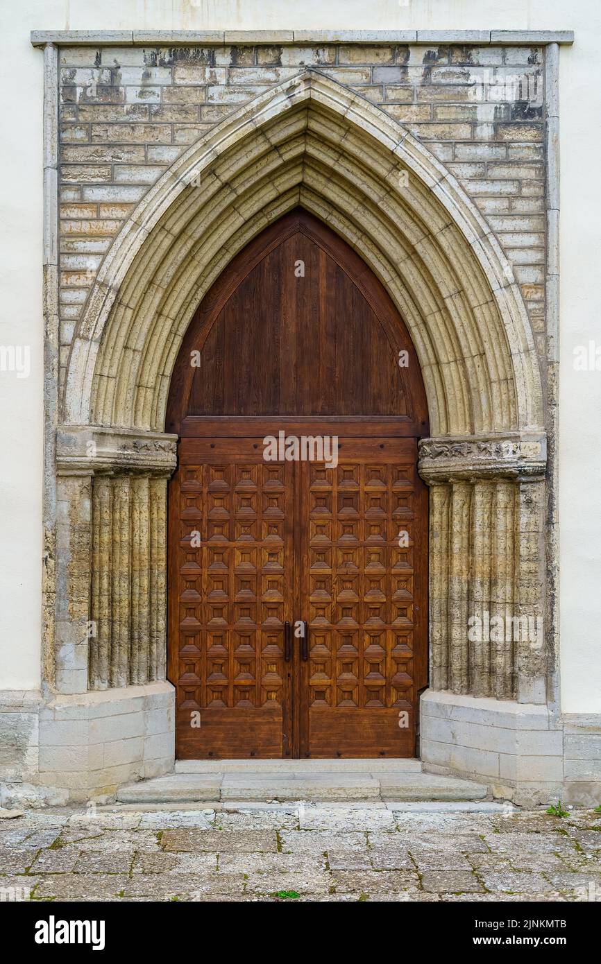 Ancient wooden door in a stone arch with also stone facade Stock Photo ...