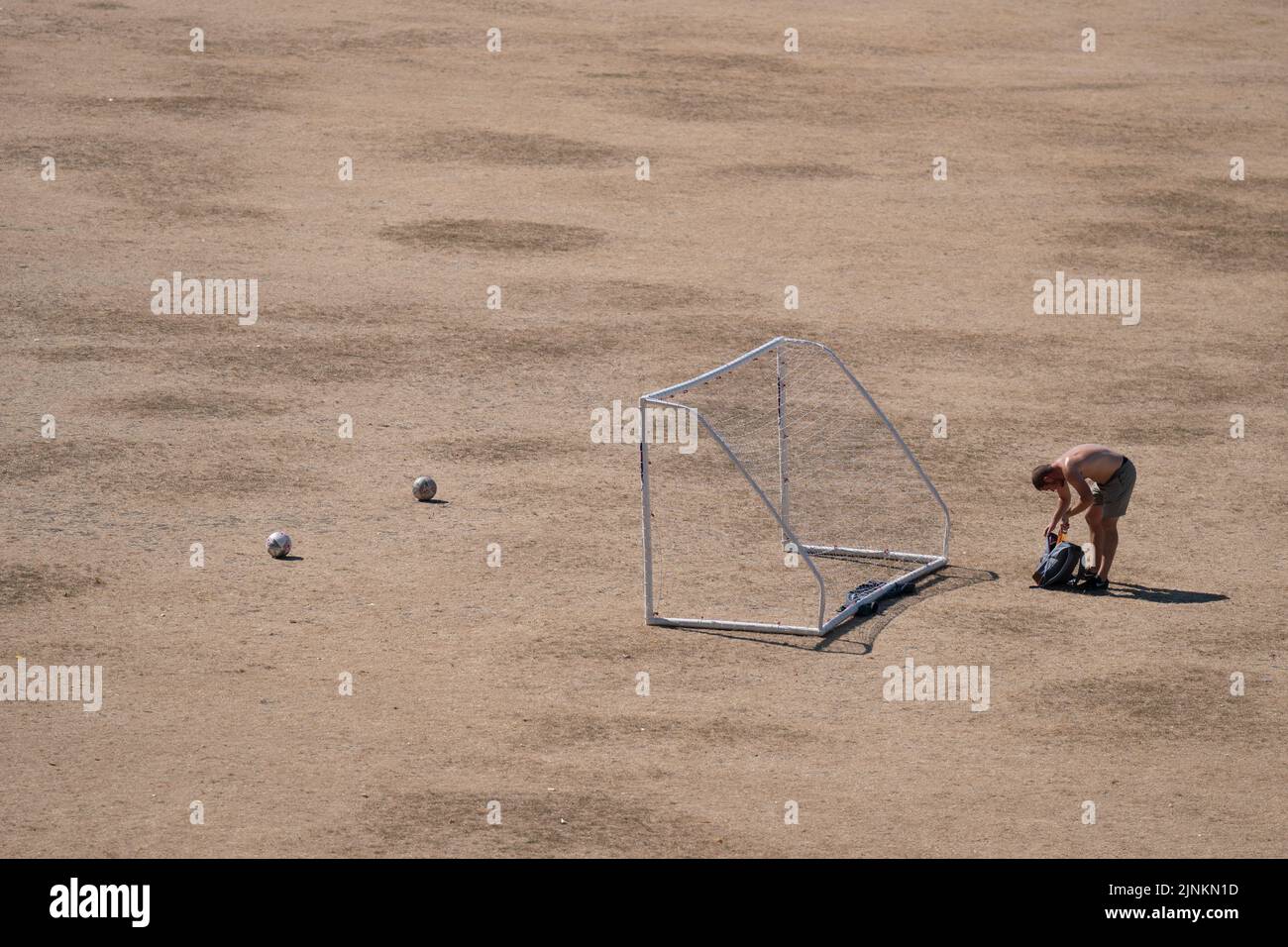 People play football on parched grass on Parker's Piece in Cambridge, as a drought has been declared for parts of England following the driest summer for 50 years. Picture date: Friday August 12, 2022. Stock Photo