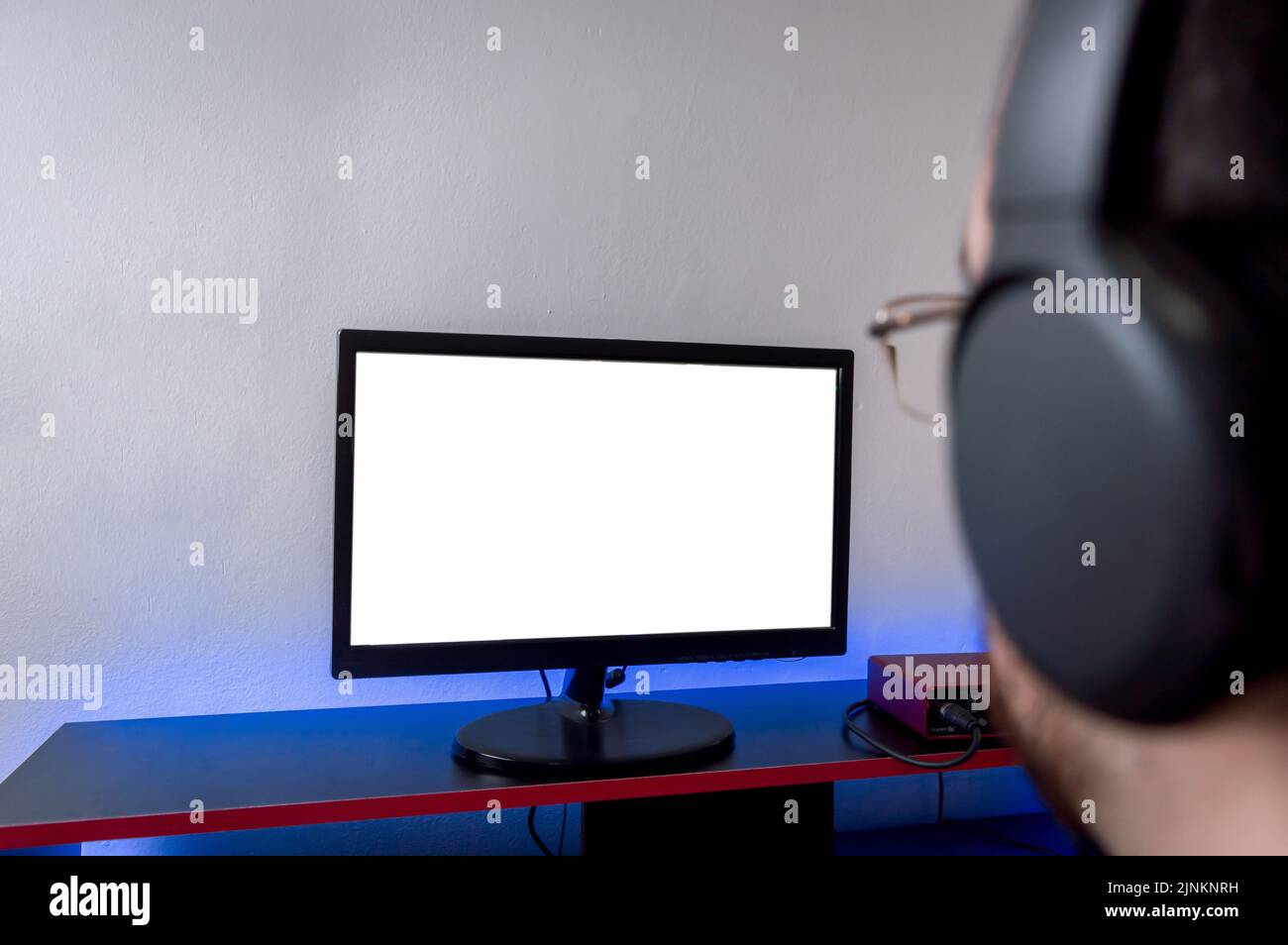 close up rear view of man with headphones watching a computer screen on ...