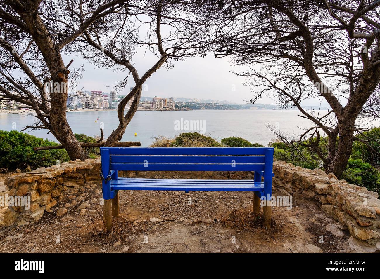 Bench to sit and contemplate the seascape with the city by the sea. Calpe Alicante. Stock Photo