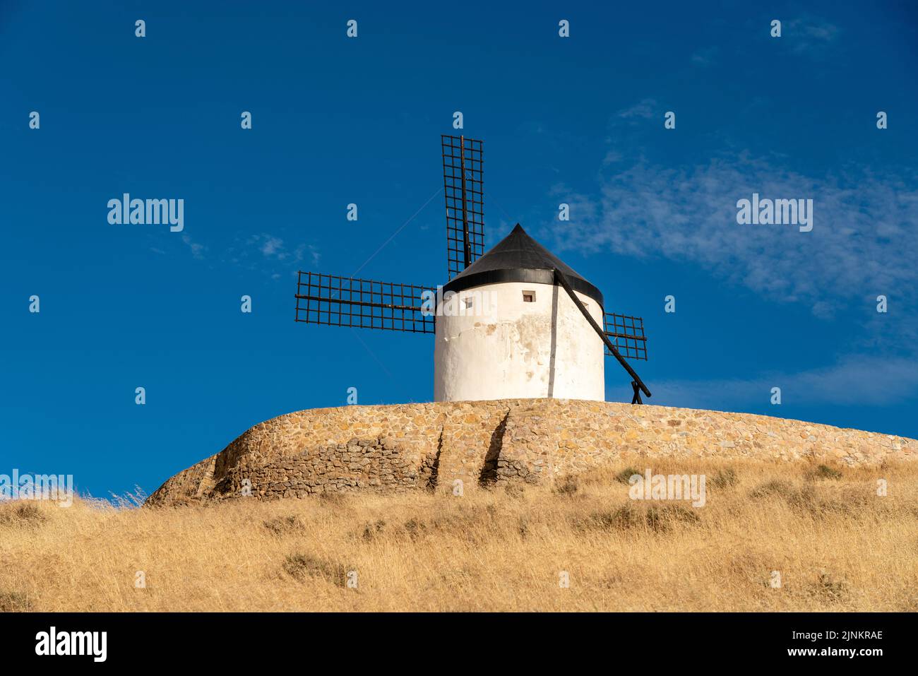 Beautiful windmill isolated in top of a hill near to Consuegra city in Castilla-La Mancha - Spain. Cloudy day. Giants Land and story of Don Quixote Stock Photo