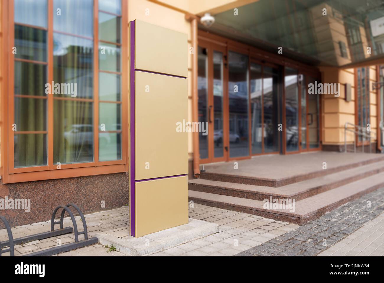 mockup, a large sign in front of a yellow building indicating the