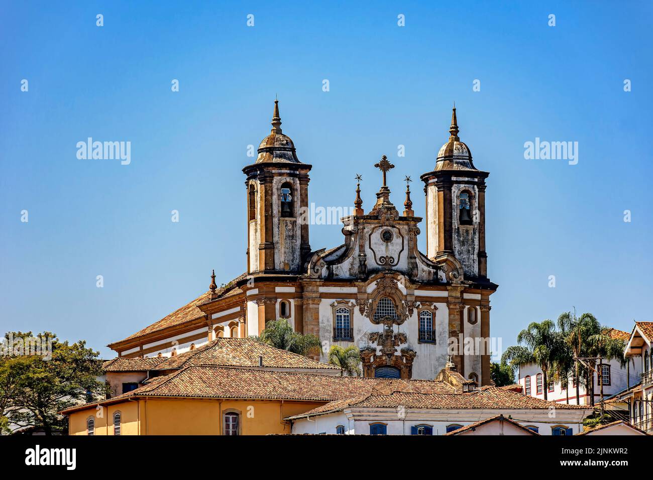 Baroque style historic church tower emerging from behind old houses in Ouro Preto city in Minas Gerais state, Brazil Stock Photo