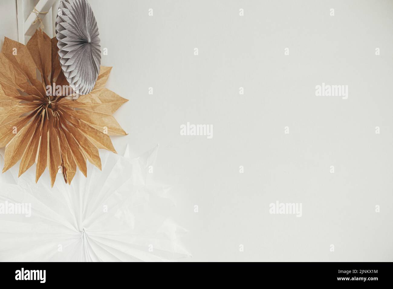 Stylish Paper Christmas Stars Hanging On White Wall Background Modern stylish-paper-christmas-stars-hanging-on-white-wall-background-modern