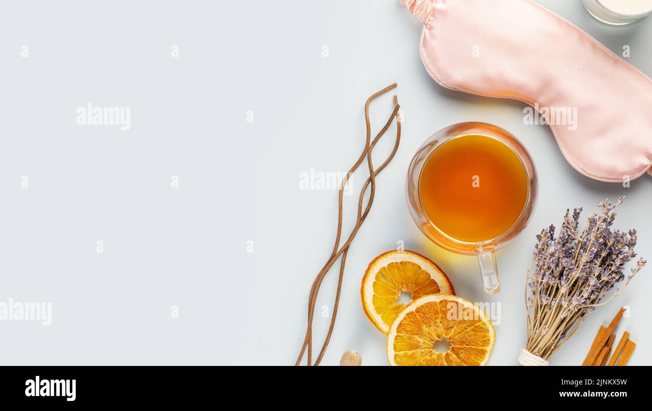 Concept of Me time and no depression. Self-care flat lay with sleep mask, lavender flower, herbal tea, dry fruits and aroma sticks on a blue backgroun Stock Photo