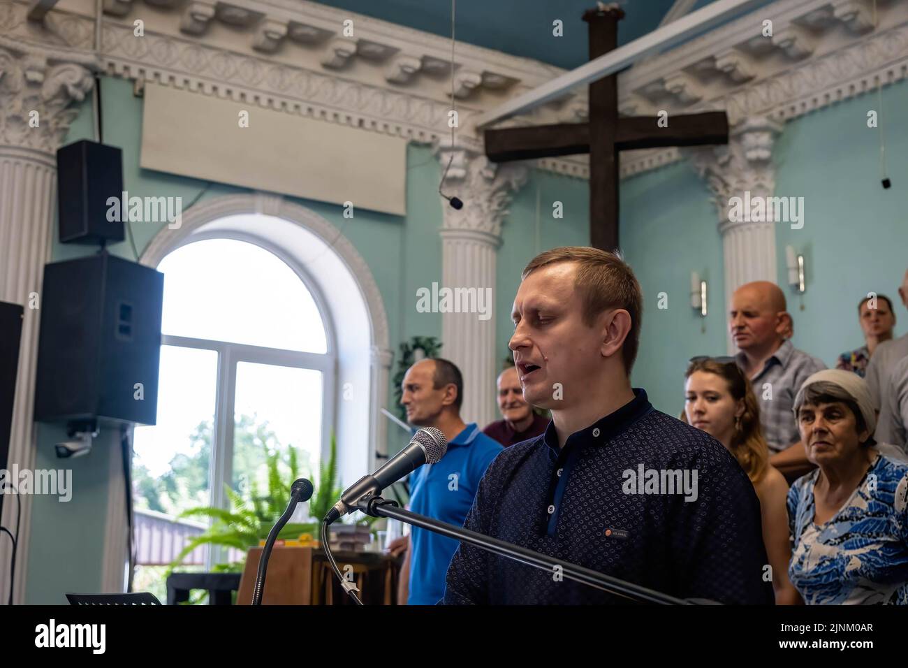 The priest, Yuri preaches the bible during a Sunday service in a Catholics church in Slovyansk, Donbas. Despite the city being continuously heavily bombarded by Russian artilleries and missiles, some residents still plan to stay in the city of Slovyansk which had a population of 106,972 (2021 est.), now stands as a main strategic city in the Donetsk region of Donbas. Since the war started, over 80% of the civilian have been evacuated from the war. Stock Photo