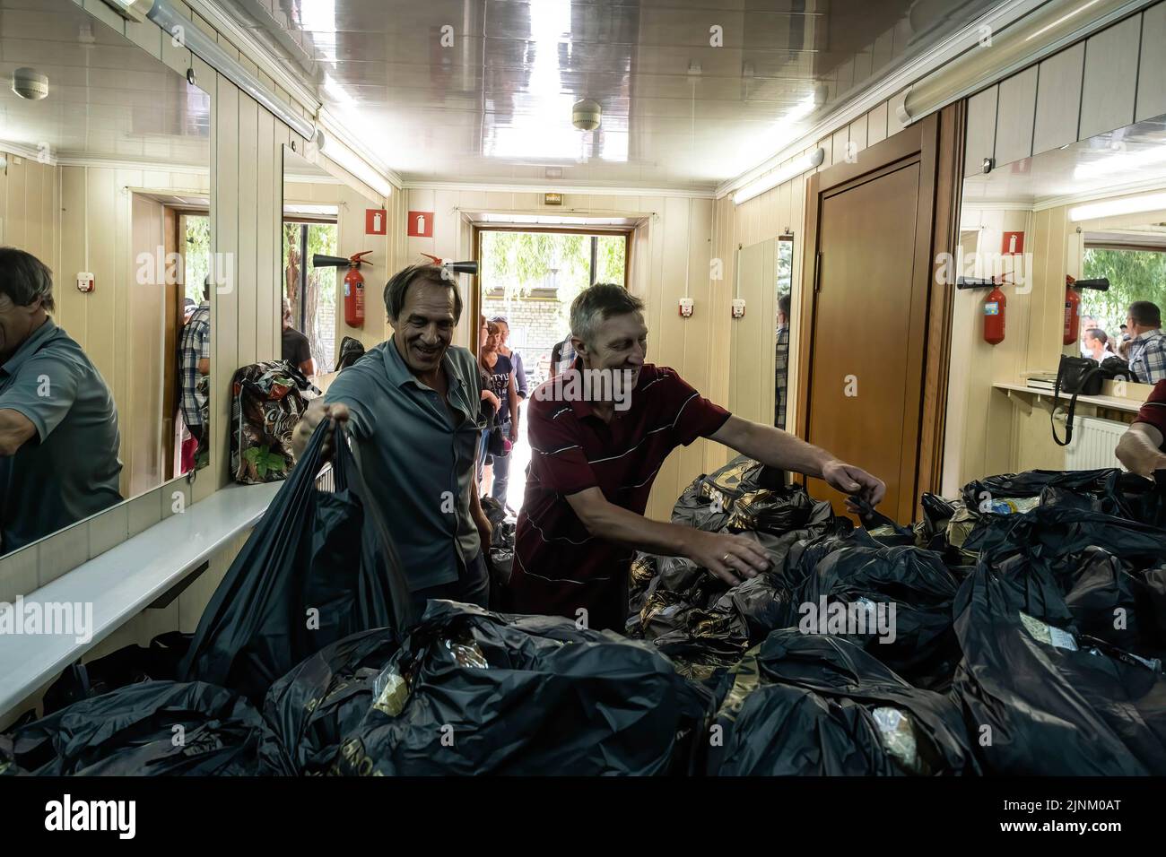 Two volunteers can be seen distributing humanitarian aid after a Sunday service in a Catholics church in Slovyansk, Donbas. Despite the city being continuously heavily bombarded by Russian artilleries and missiles, some residents still plan to stay in the city of Slovyansk which had a population of 106,972 (2021 est.), now stands as a main strategic city in the Donetsk region of Donbas. Since the war started, over 80% of the civilian have been evacuated from the war. Stock Photo